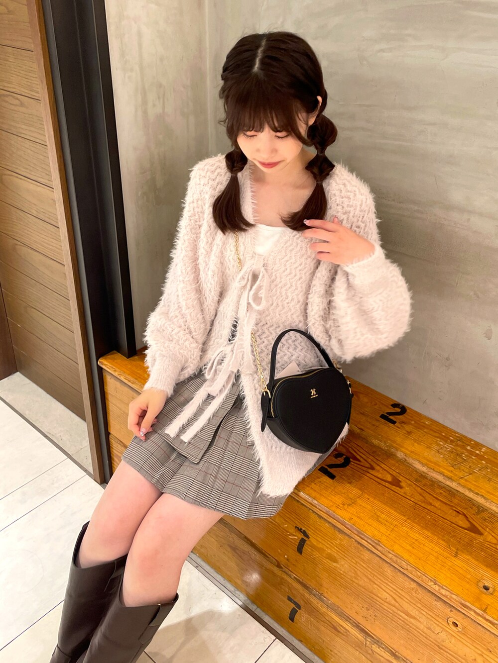 ピンク系のカーディガン/ボレロ、その他のスカート、ホワイト系のショルダーバッグを着用したレディースの秋コーディネートの2枚目の写真