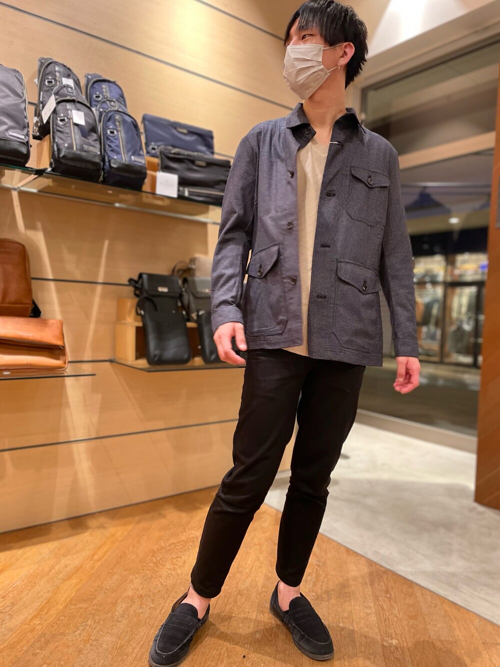 グレー系のブルゾン、ベージュ系のTシャツ/カットソー、ブラック系のチノパンツを着用したメンズの春コーディネートの2枚目の写真