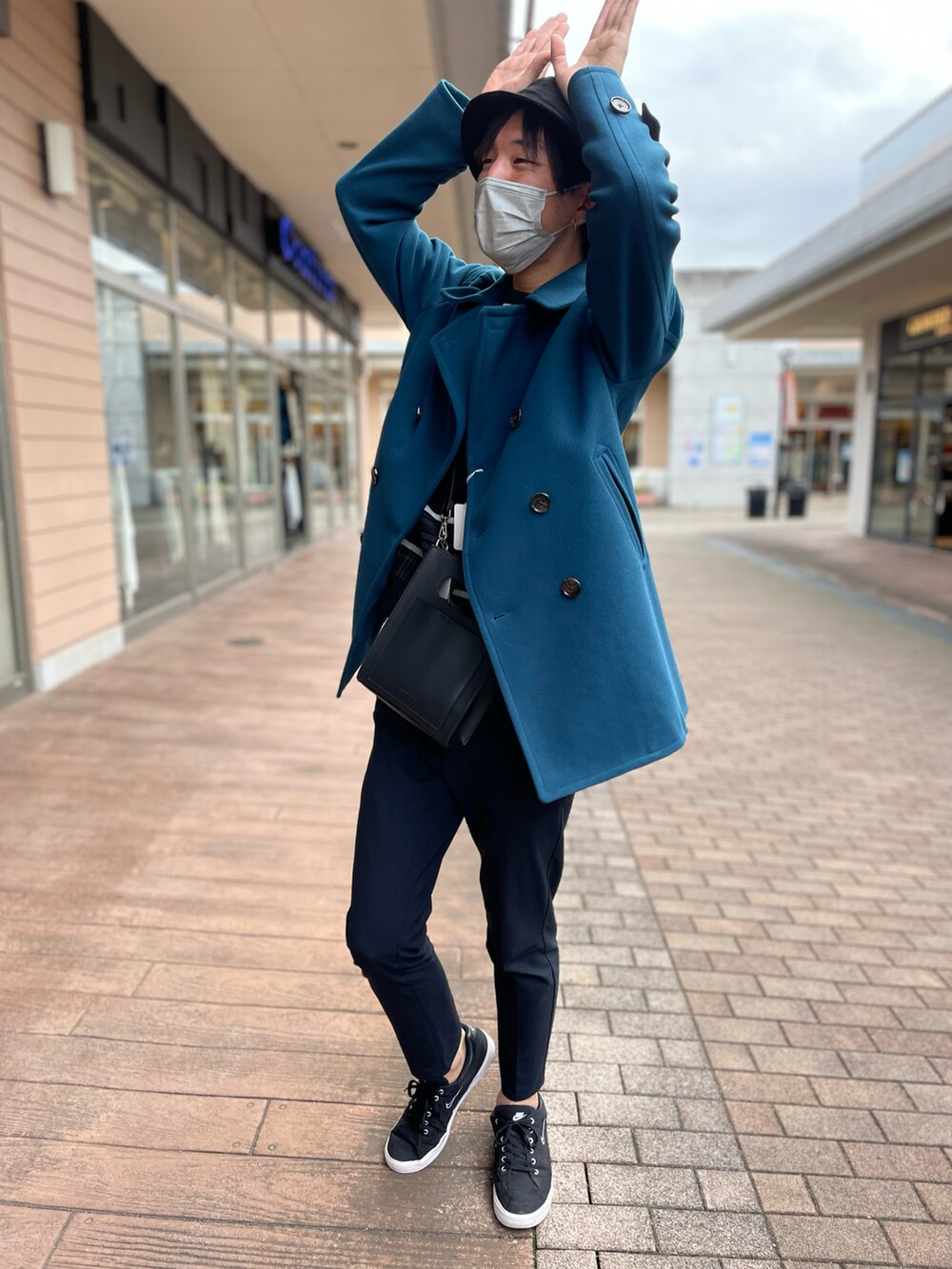 ブルー系のピーコート、ブラック系のニット/セーター、ブラック系のショルダーバッグを着用したメンズの秋コーディネートの2枚目の写真