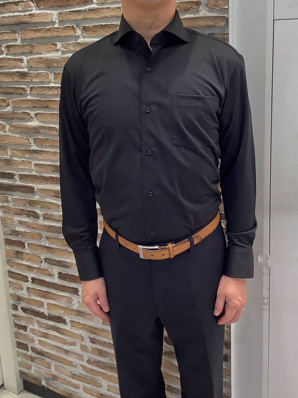 ブラック系のビジネスシャツを着用したメンズの秋コーディネートの2枚目の写真