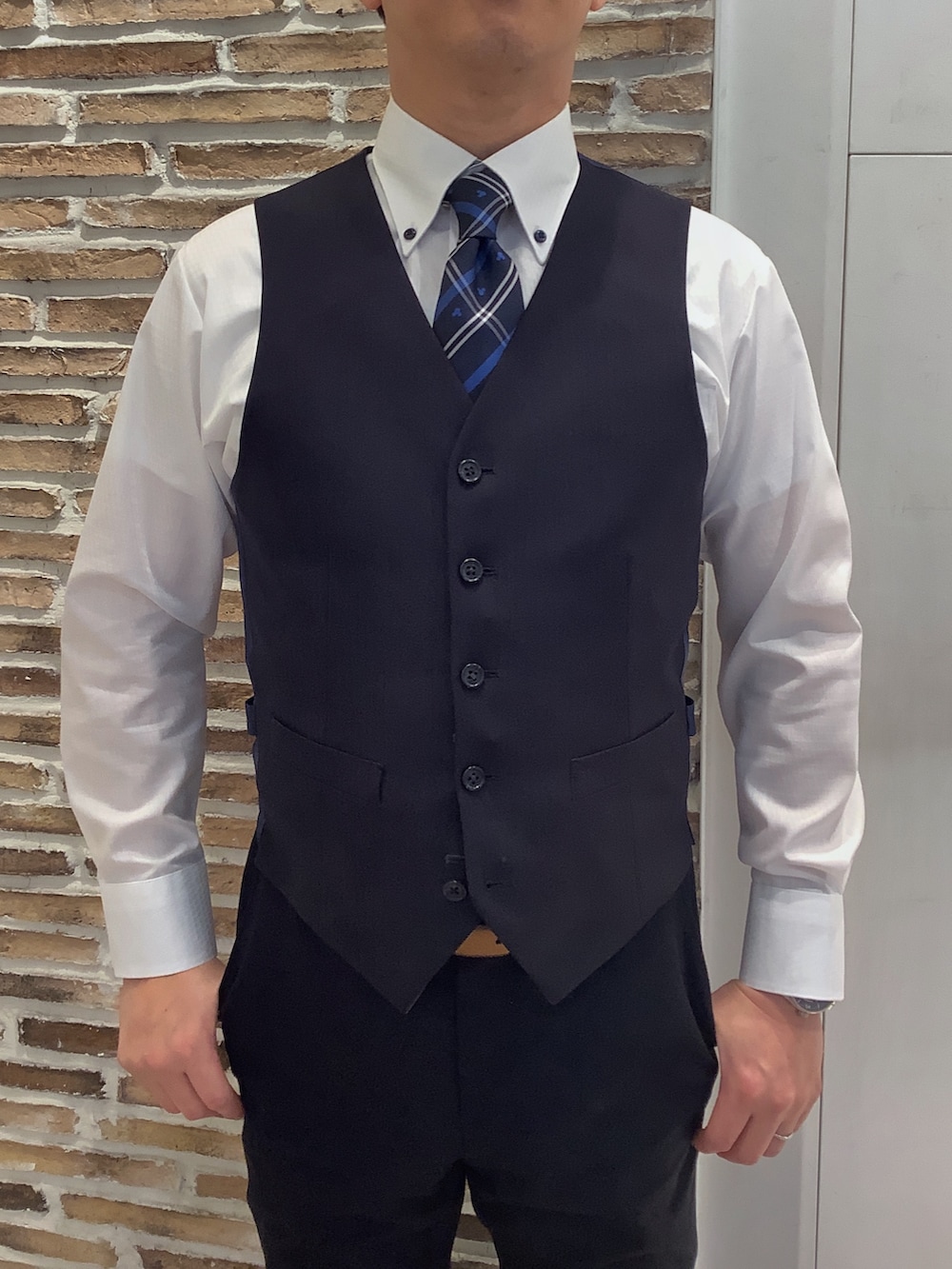 ホワイト系のビジネスシャツ、ブルー系のネクタイを着用したメンズの冬コーディネートの2枚目の写真