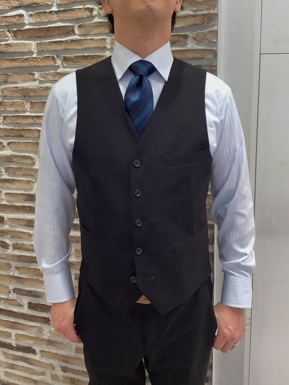 ブルー系のビジネスシャツ、ブルー系のネクタイを着用したメンズの冬コーディネートの2枚目の写真