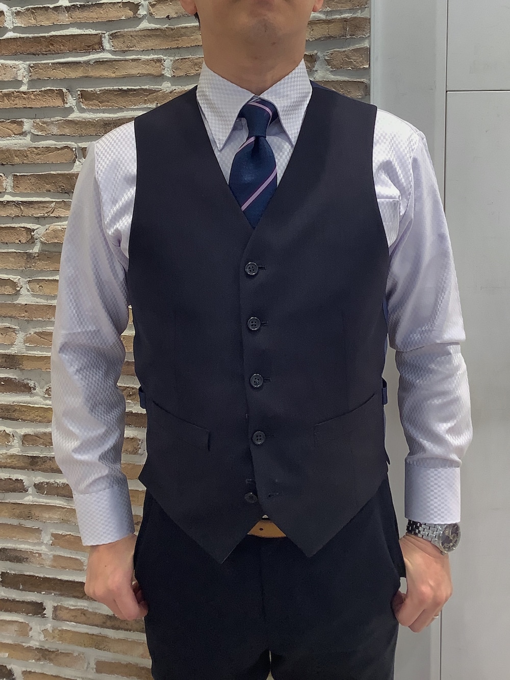 パープル系のビジネスシャツ、ブルー系のネクタイを着用したメンズの冬コーディネートの2枚目の写真