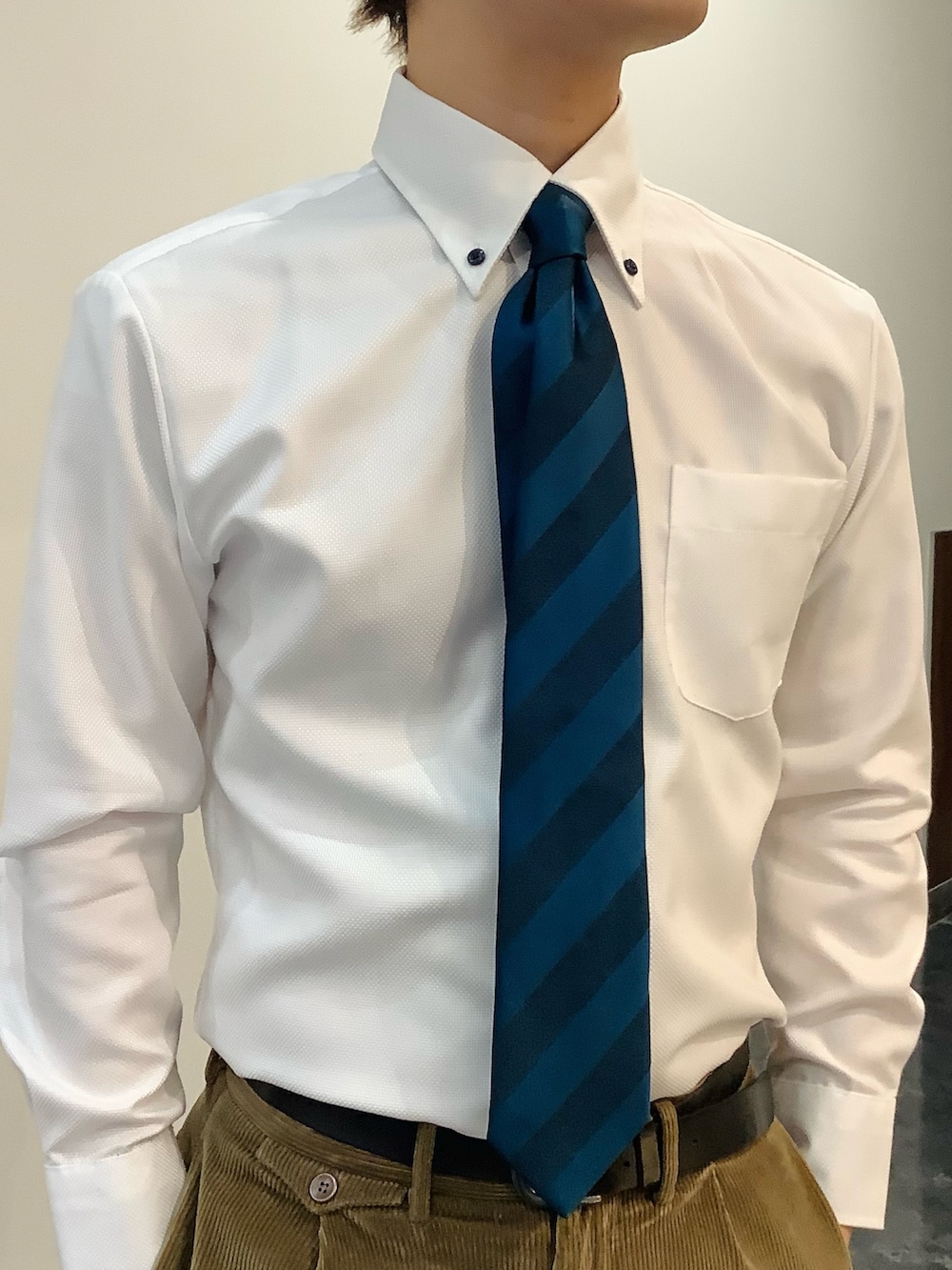 ホワイト系のビジネスシャツ、ブルー系のネクタイ、ブラウン系のベストを着用したメンズの冬コーディネートの6枚目の写真