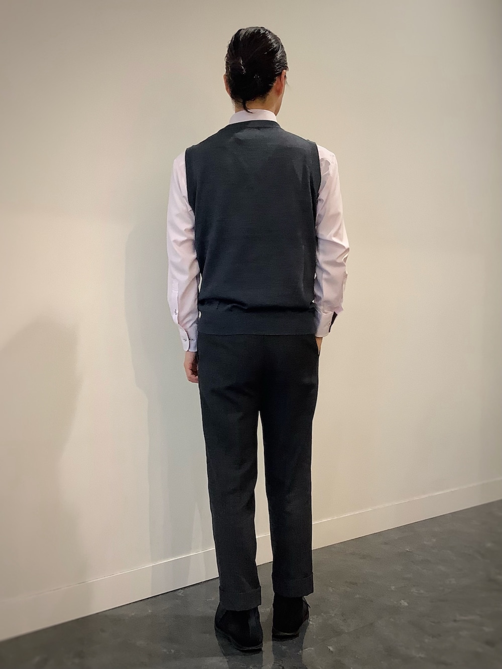 グレー系のベスト、ピンク系のビジネスシャツ、グレー系のビジネスバッグを着用したメンズの秋コーディネートの4枚目の写真