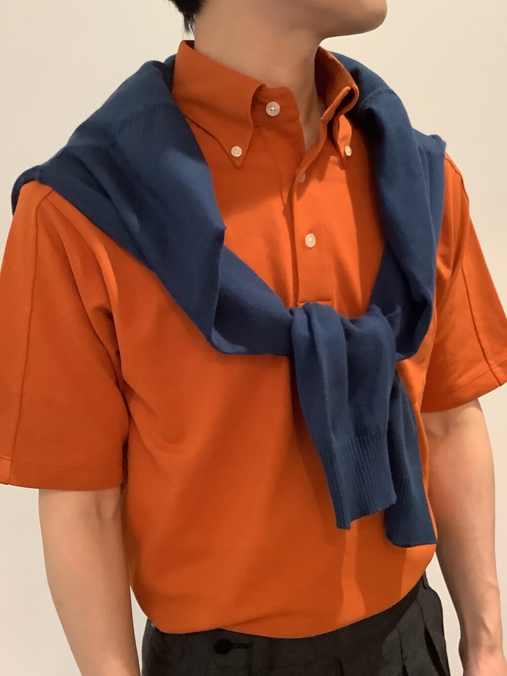 オレンジ系のポロシャツ、ブルー系のカーディガン/ボレロを着用したメンズの夏コーディネートの4枚目の写真