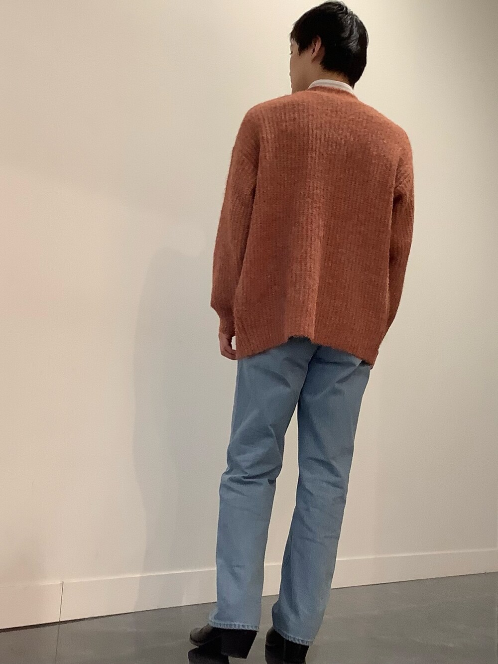 オレンジ系のカーディガン/ボレロ、グリーン系のビジネスシャツ、ブルー系のデニムパンツを着用したメンズの冬コーディネートの3枚目の写真