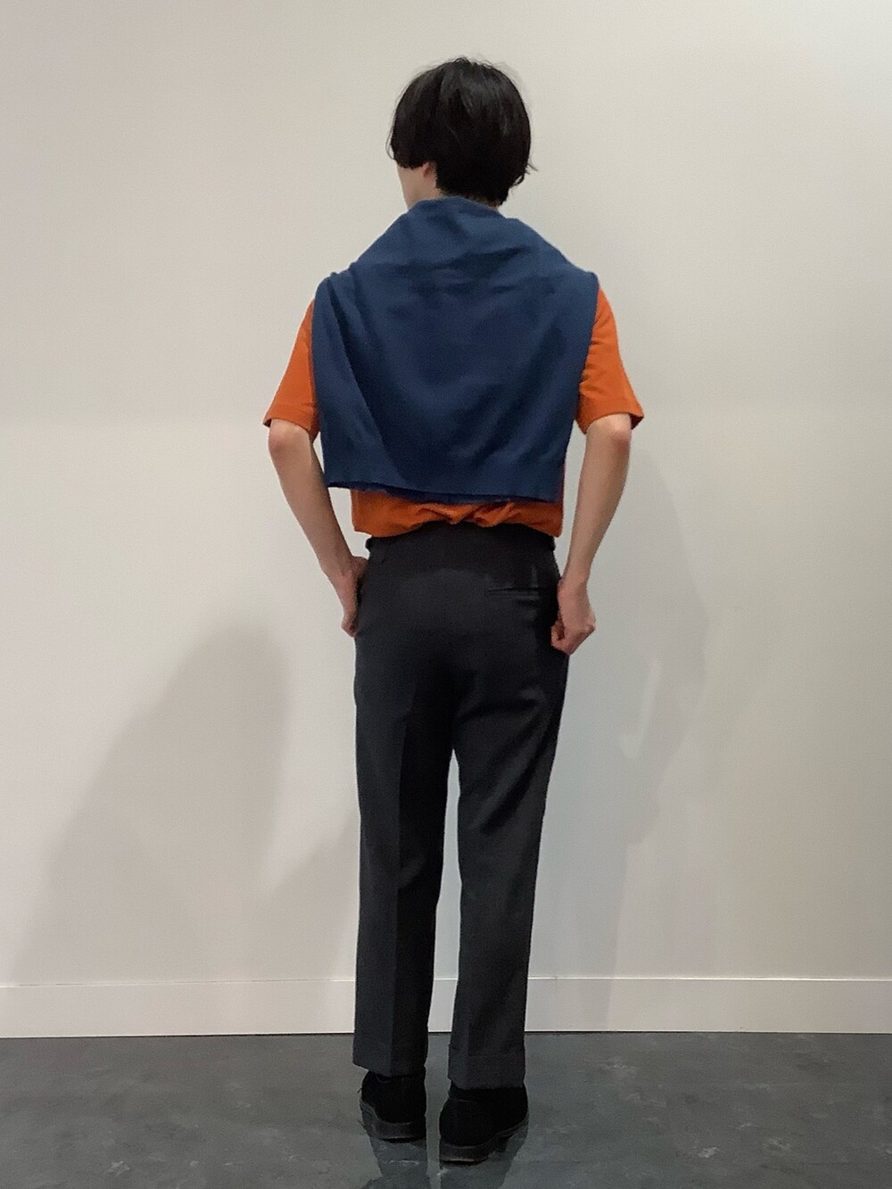 オレンジ系のポロシャツ、ブルー系のカーディガン/ボレロを着用したメンズの夏コーディネートの3枚目の写真