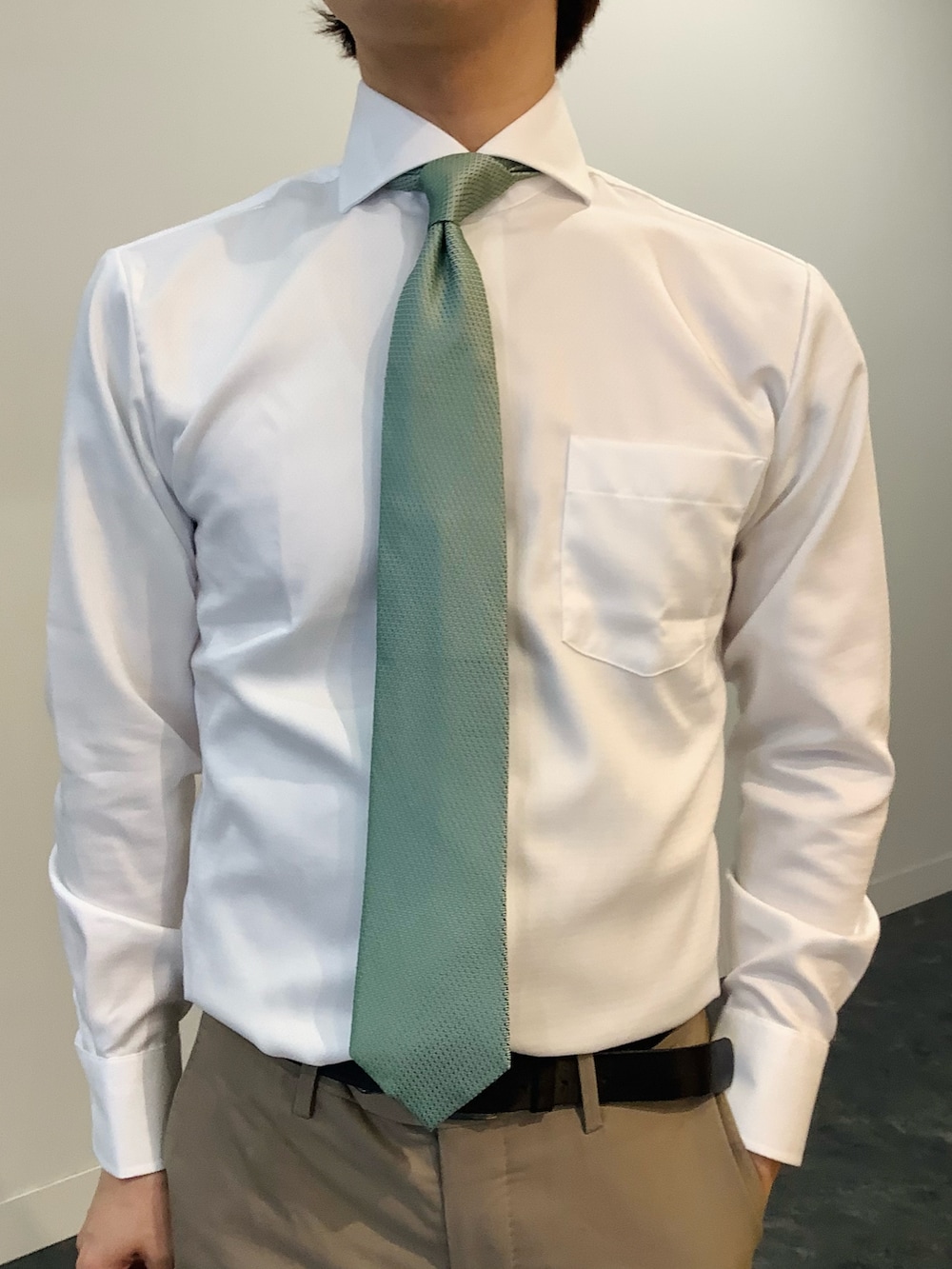 ブルー系のテーラードジャケット、ホワイト系のビジネスシャツ、グリーン系のネクタイを着用したメンズの冬コーディネートの4枚目の写真