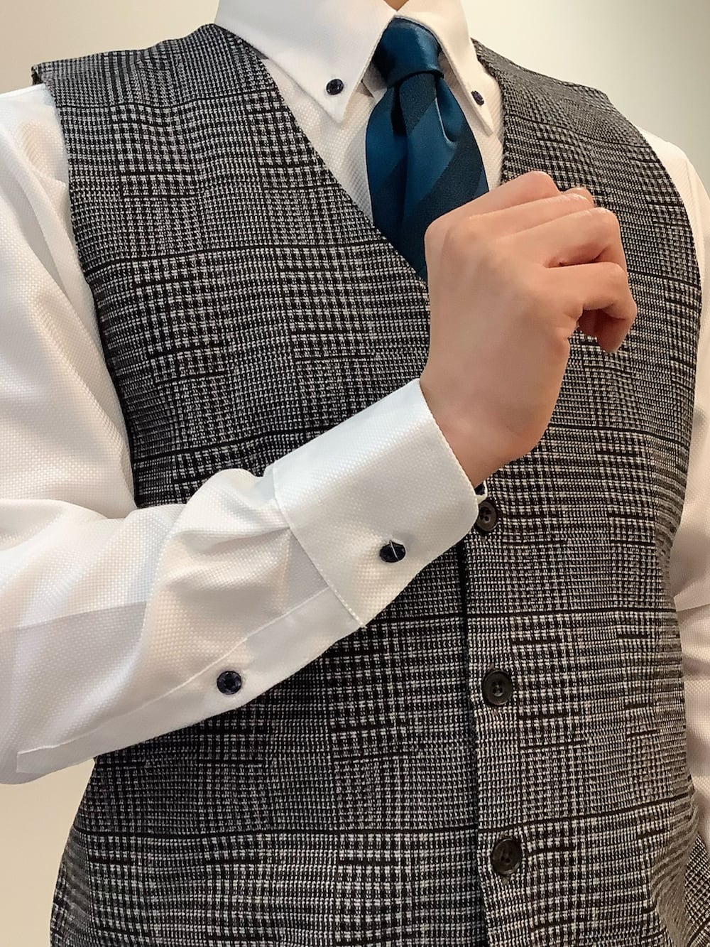 ホワイト系のビジネスシャツ、ブルー系のネクタイ、ブラウン系のベストを着用したメンズの冬コーディネートの4枚目の写真