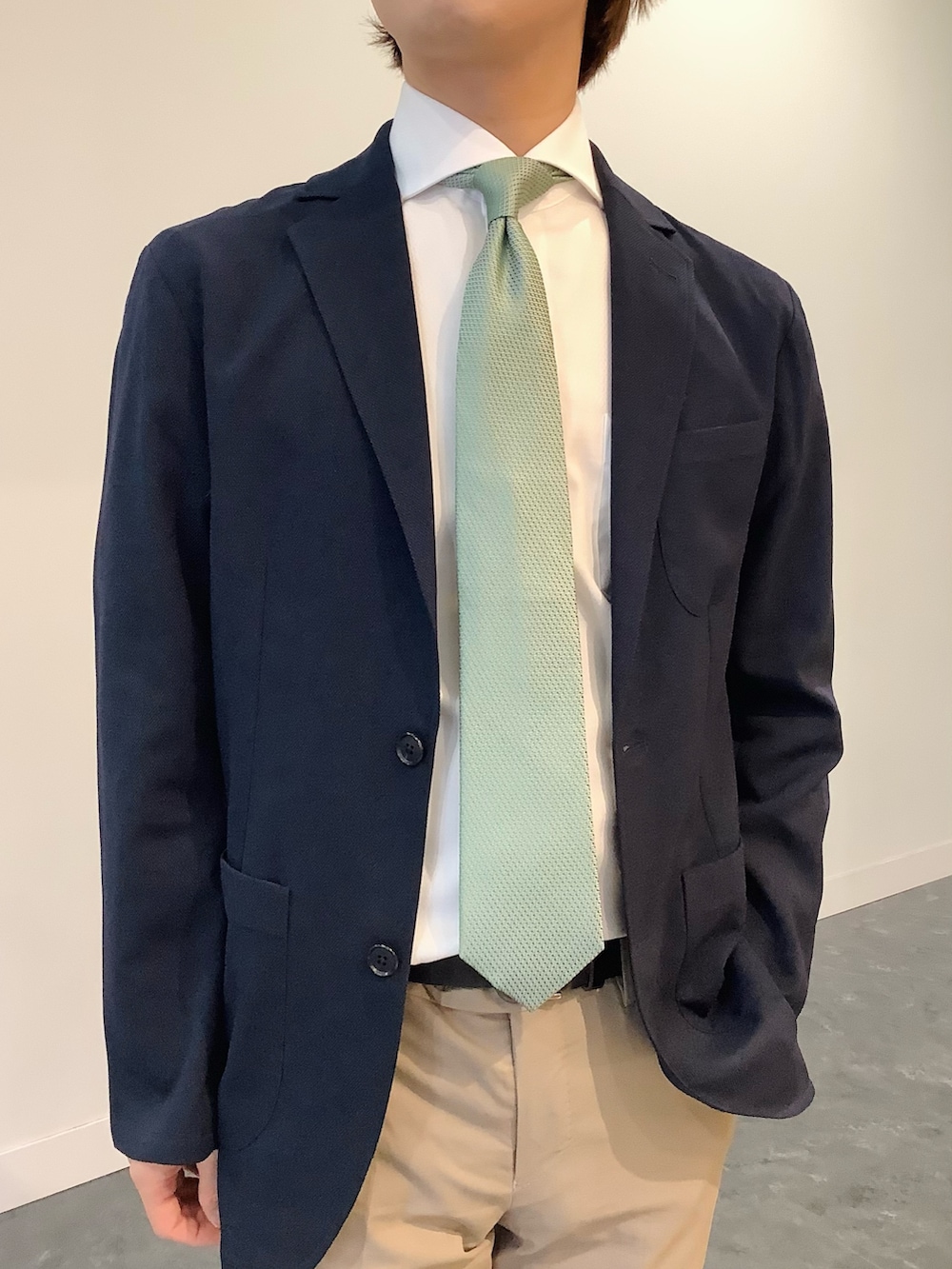 ブルー系のテーラードジャケット、ホワイト系のビジネスシャツ、グリーン系のネクタイを着用したメンズの冬コーディネートの2枚目の写真