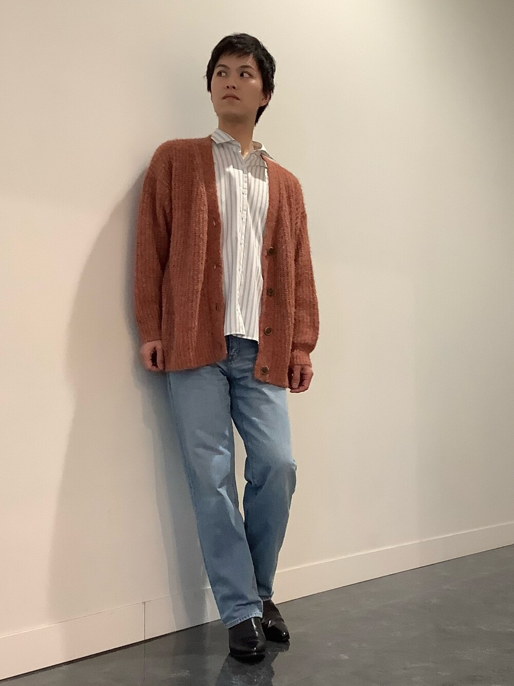 オレンジ系のカーディガン/ボレロ、グリーン系のビジネスシャツ、ブルー系のデニムパンツを着用したメンズの冬コーディネートの2枚目の写真