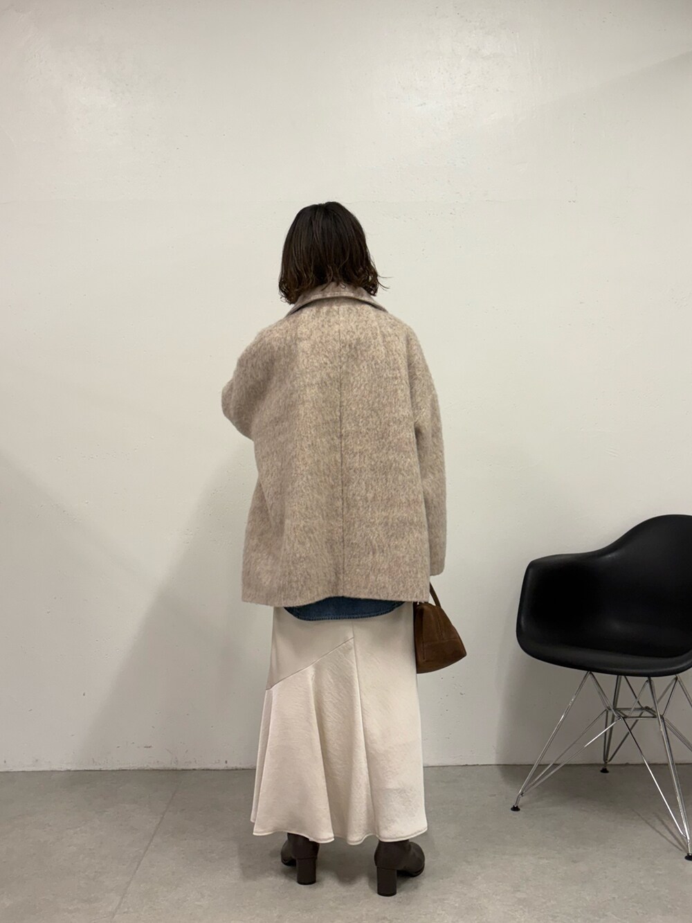 ホワイト系のスカート、ブラウン系のボストンバッグ、ブラウン系のブーツを着用したレディースの秋コーディネートの4枚目の写真