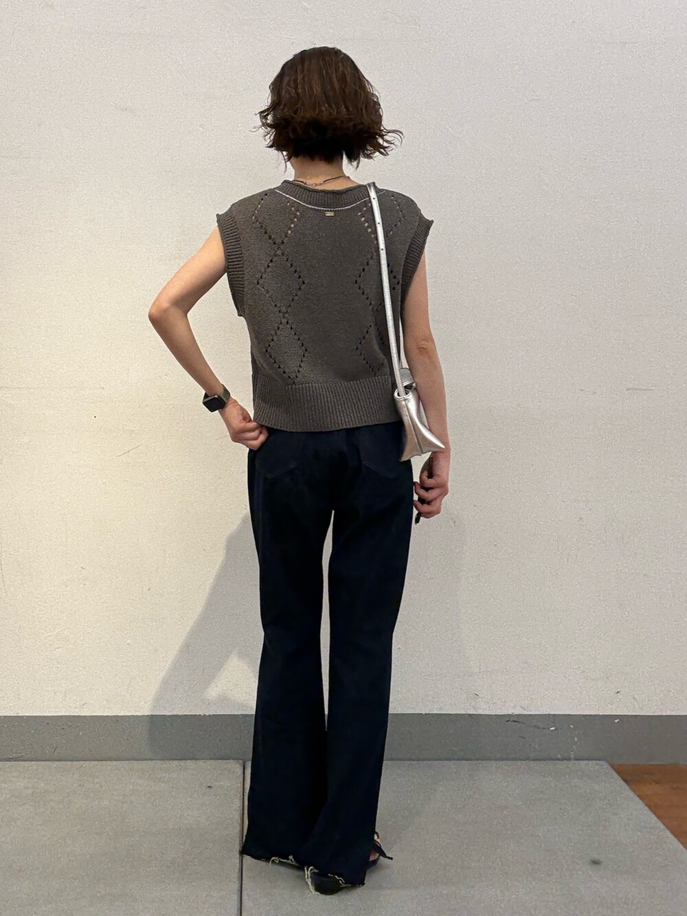ブルー系のデニムパンツ、シルバー系のショルダーバッグ、グレー系のニット/セーターを着用したレディースの夏コーディネートの3枚目の写真