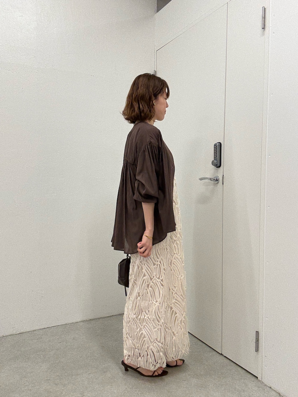 ブラウン系のシャツ/ブラウス、ホワイト系のワンピース、ブラウン系のショルダーバッグを着用したレディースの夏コーディネートの4枚目の写真