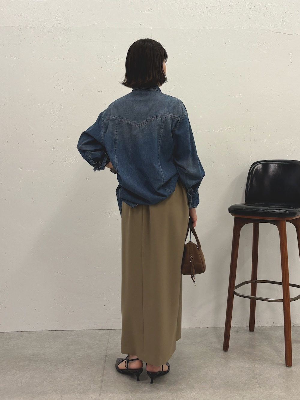 ブルー系のシャツ/ブラウス、ベージュ系のスカート、ブラック系のパンプスを着用したレディースの秋コーディネートの3枚目の写真