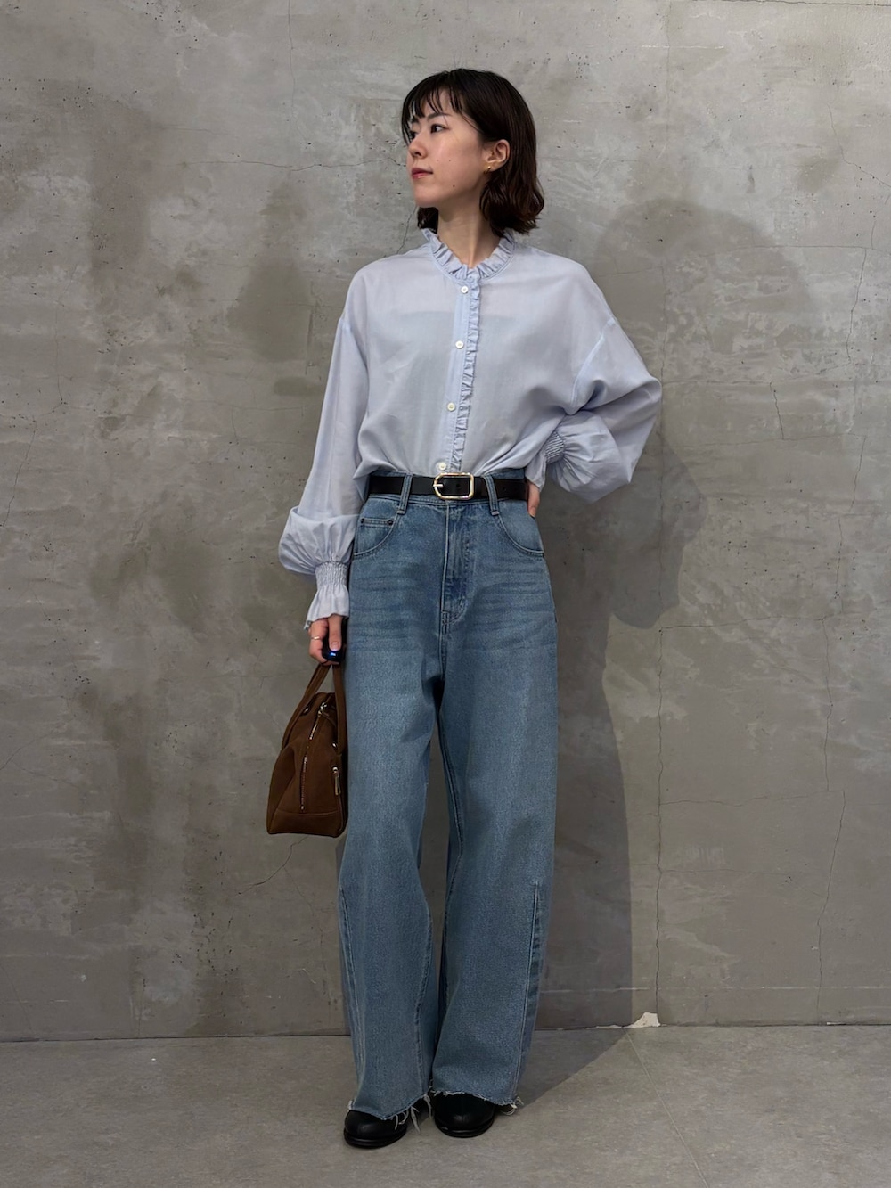 ブラック系のブーツ、ブラウン系のボストンバッグ、ブルー系のシャツ/ブラウスを着用したレディースの秋コーディネートの4枚目の写真