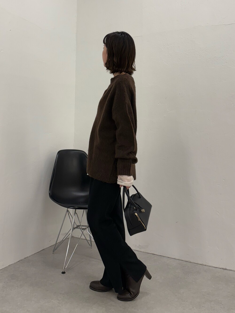 ブラック系のその他パンツ、ブラック系のボストンバッグ、ブラック系のブーツを着用したレディースの秋コーディネートの4枚目の写真