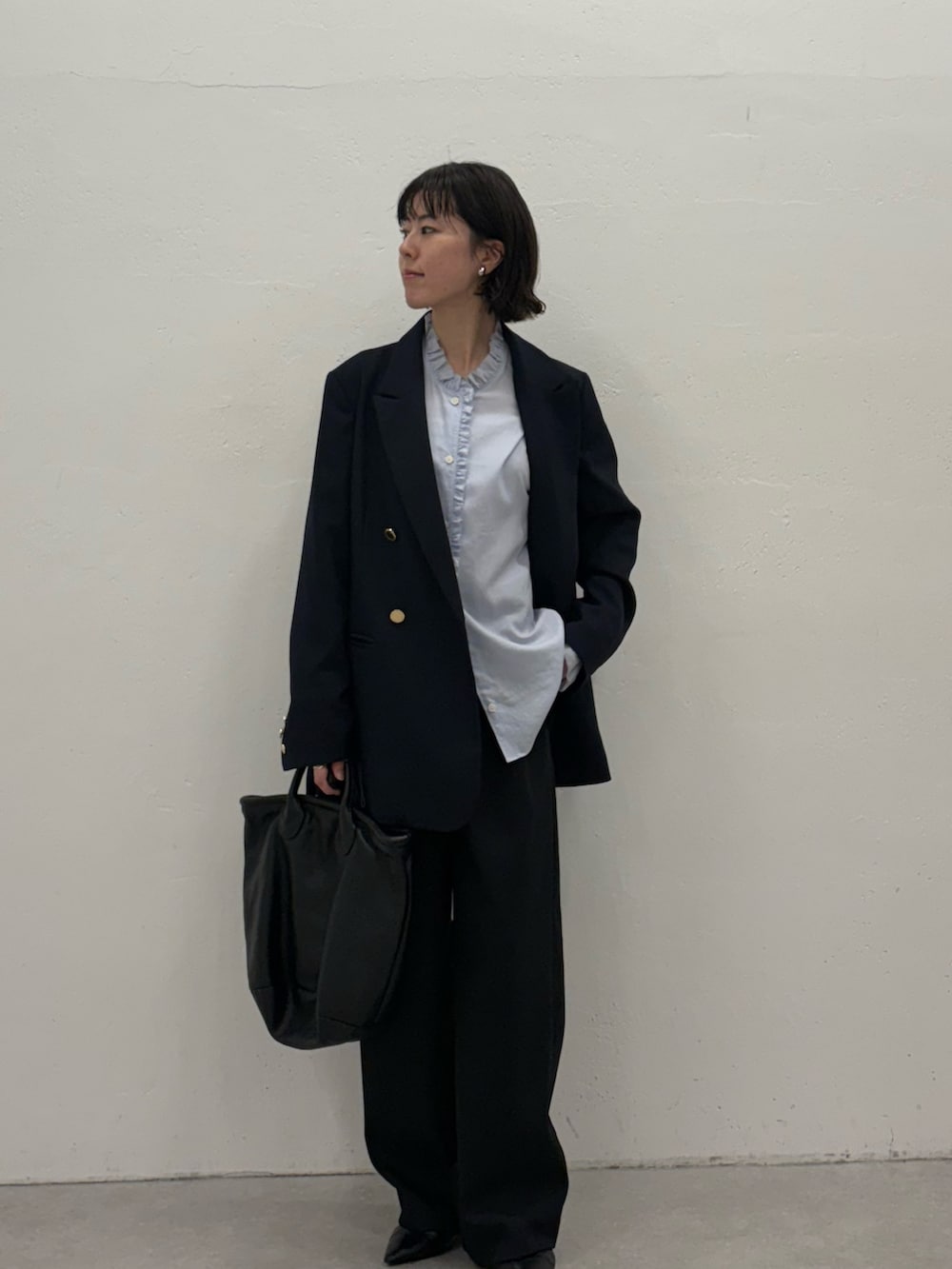 ブルー系のスラックス、ブルー系のテーラードジャケット、ブラック系のトートバッグを着用したレディースの秋コーディネートの5枚目の写真