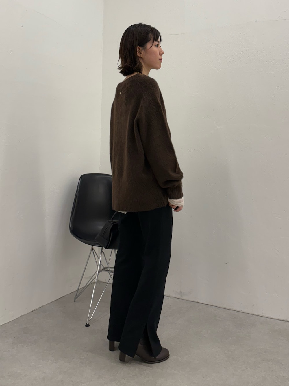 ブラック系のその他パンツ、ブラック系のボストンバッグ、ブラック系のブーツを着用したレディースの秋コーディネートの2枚目の写真