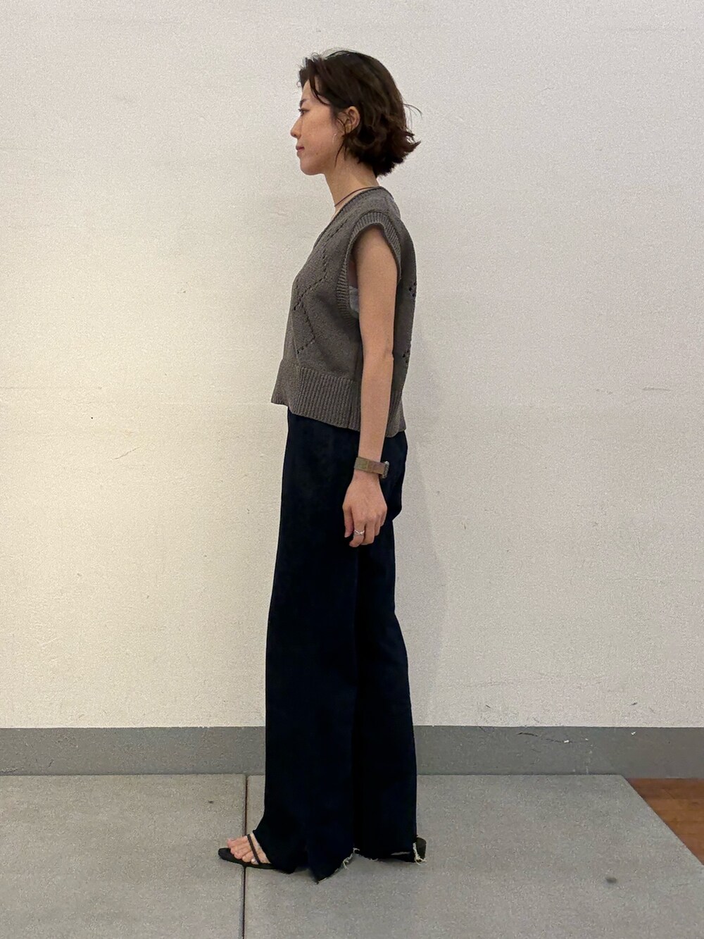 ブルー系のデニムパンツ、シルバー系のショルダーバッグ、グレー系のニット/セーターを着用したレディースの夏コーディネートの2枚目の写真