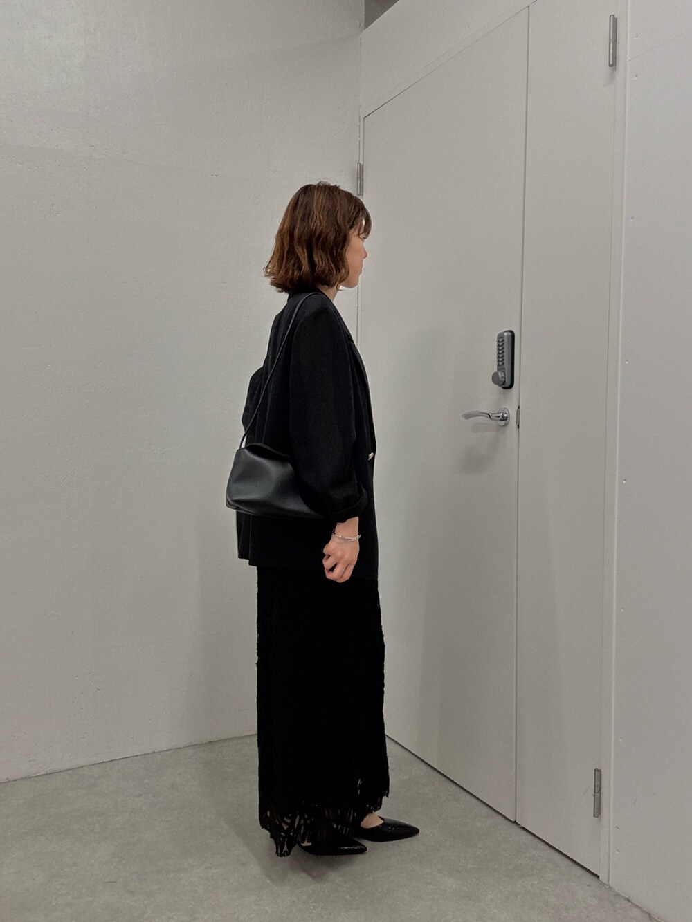 ブラック系のワンピース、ブラック系のテーラードジャケット、ブラック系のパンプスを着用したレディースの夏コーディネートの4枚目の写真