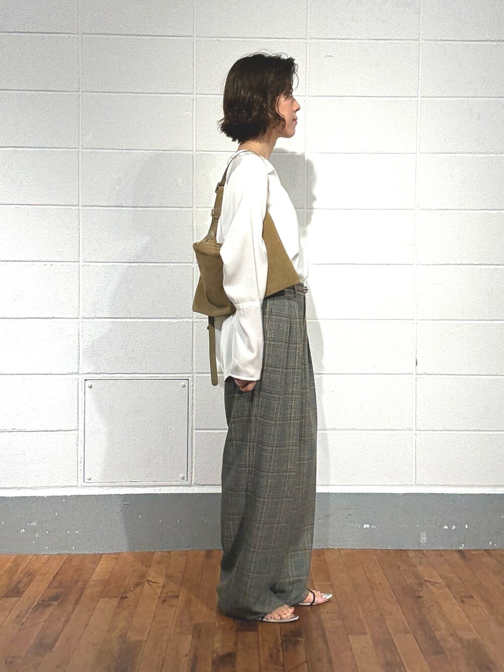 グレー系のスラックス、ベージュ系のショルダーバッグ、ホワイト系のシャツ/ブラウスを着用したレディースの夏コーディネートの4枚目の写真