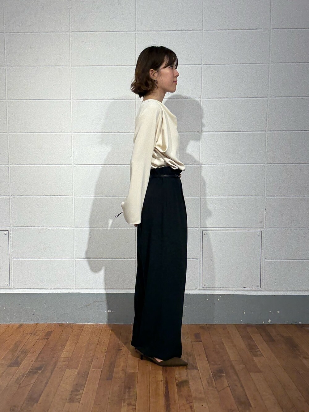 ブルー系のスラックス、ブラウン系のパンプス、ホワイト系のシャツ/ブラウスを着用したレディースの秋コーディネートの2枚目の写真