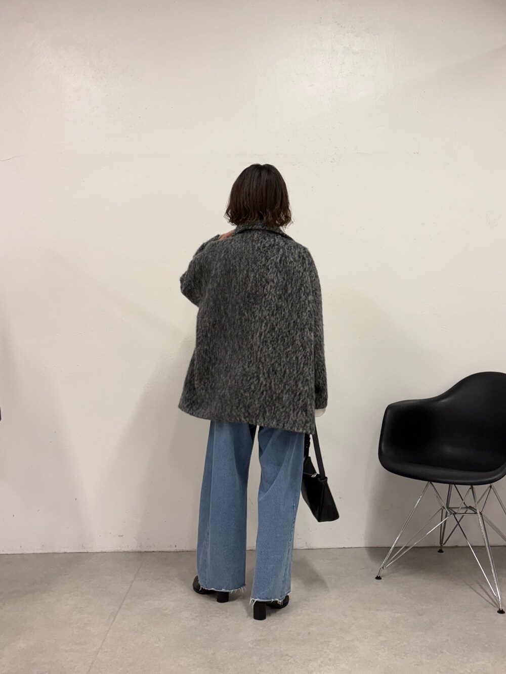 ホワイト系のニット/セーター、ブルー系のデニムパンツ、ブラック系のショルダーバッグを着用したレディースの秋コーディネートの3枚目の写真