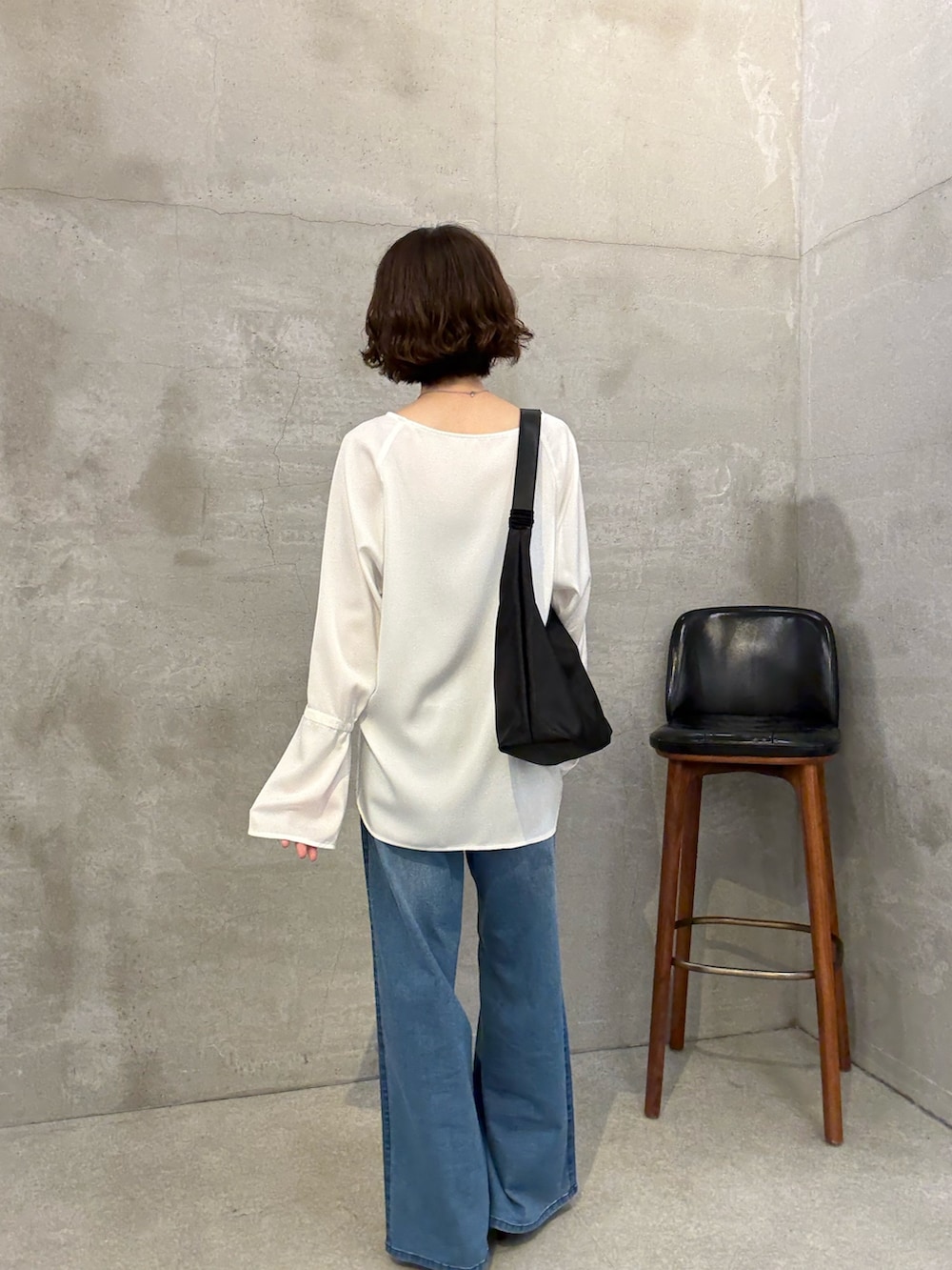 ブルー系のデニムパンツ、ホワイト系のシャツ/ブラウス、ブラック系のパンプスを着用したレディースの夏コーディネートの3枚目の写真