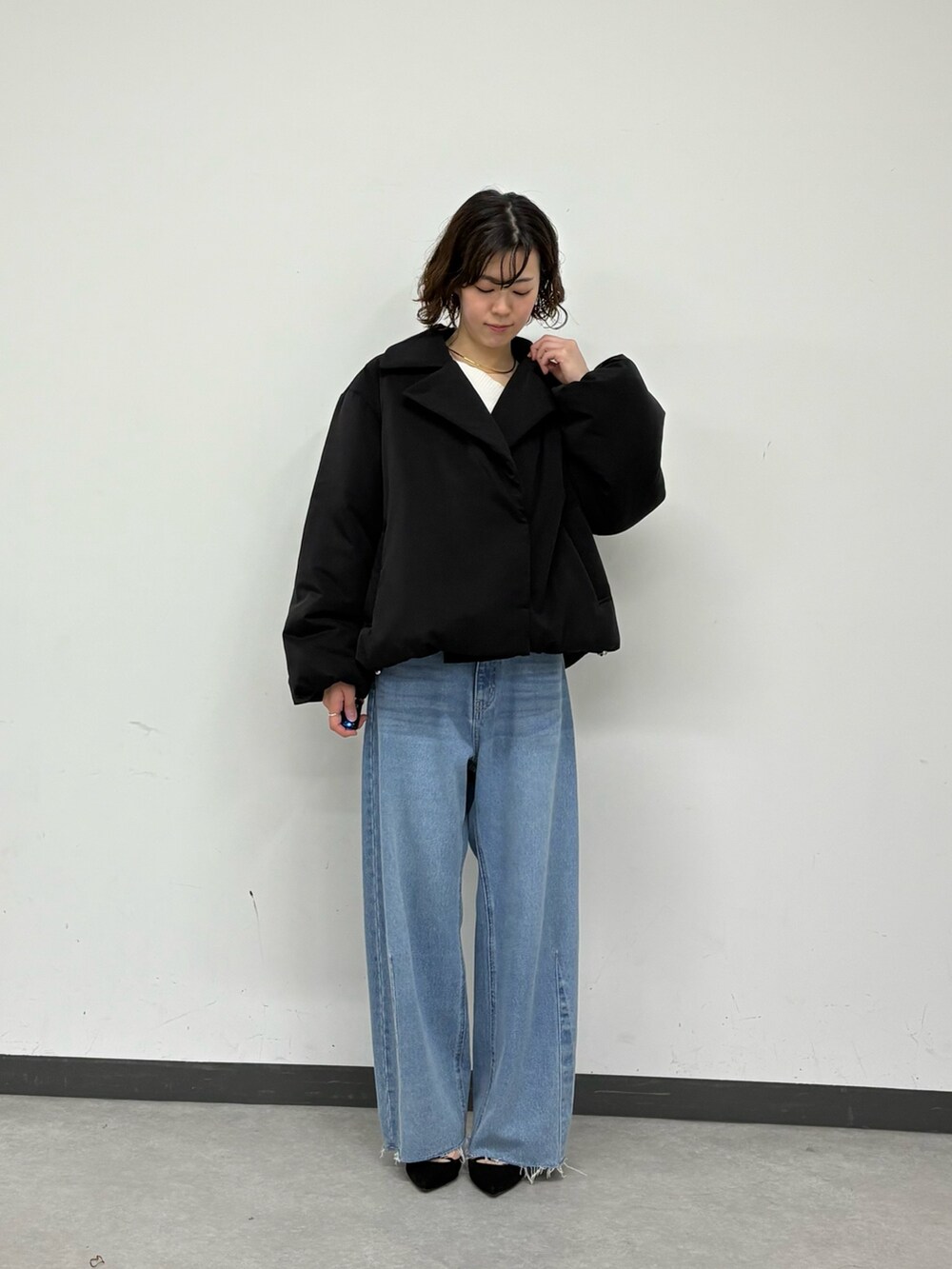 ブラック系のその他アウター、ブルー系のデニムパンツ、ホワイト系のニット/セーターを着用したレディースの秋コーディネートの5枚目の写真