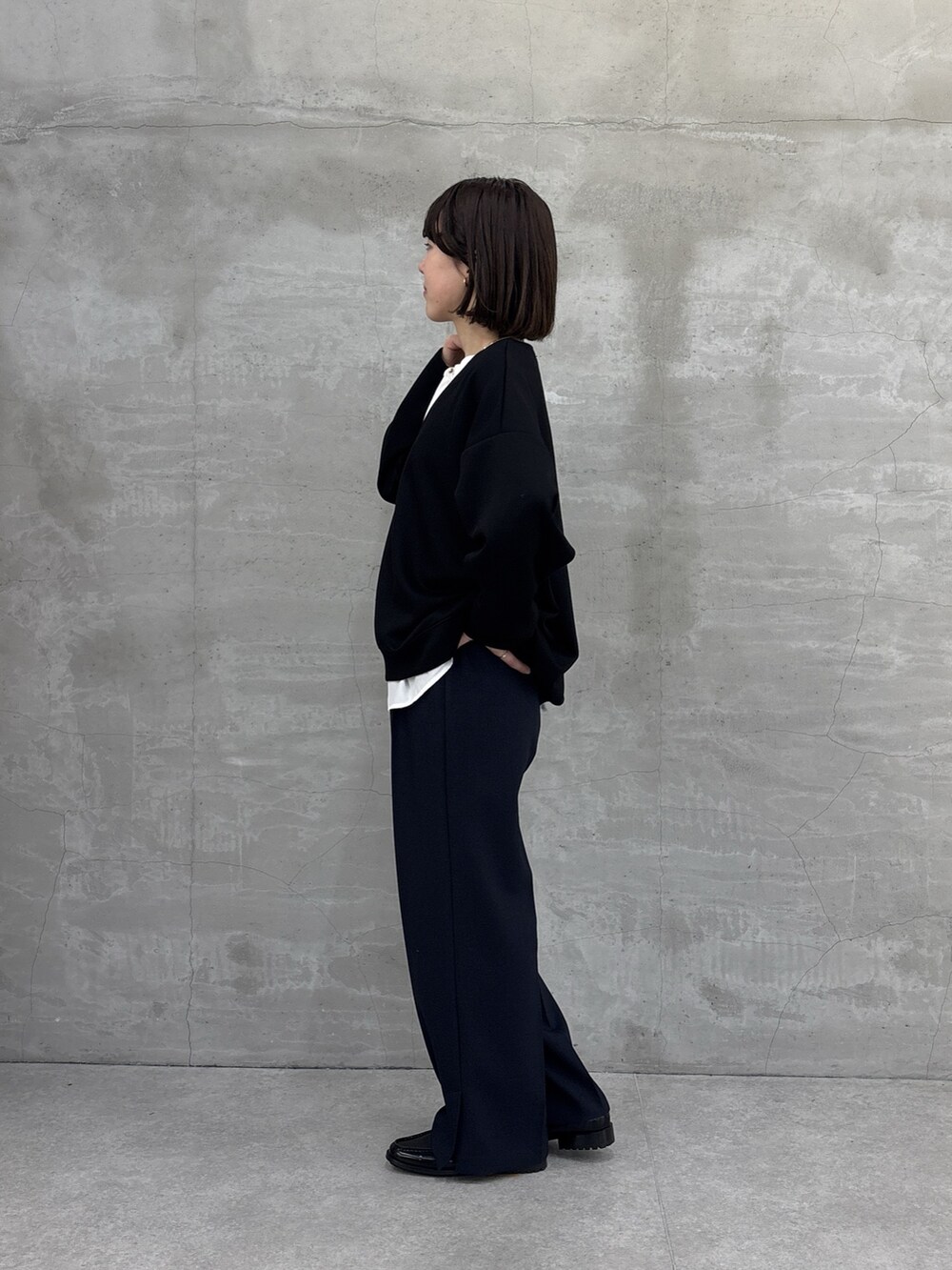 ブラック系のTシャツ/カットソー、ブルー系のスラックス、ホワイト系のシャツ/ブラウスを着用したレディースの冬コーディネートの4枚目の写真