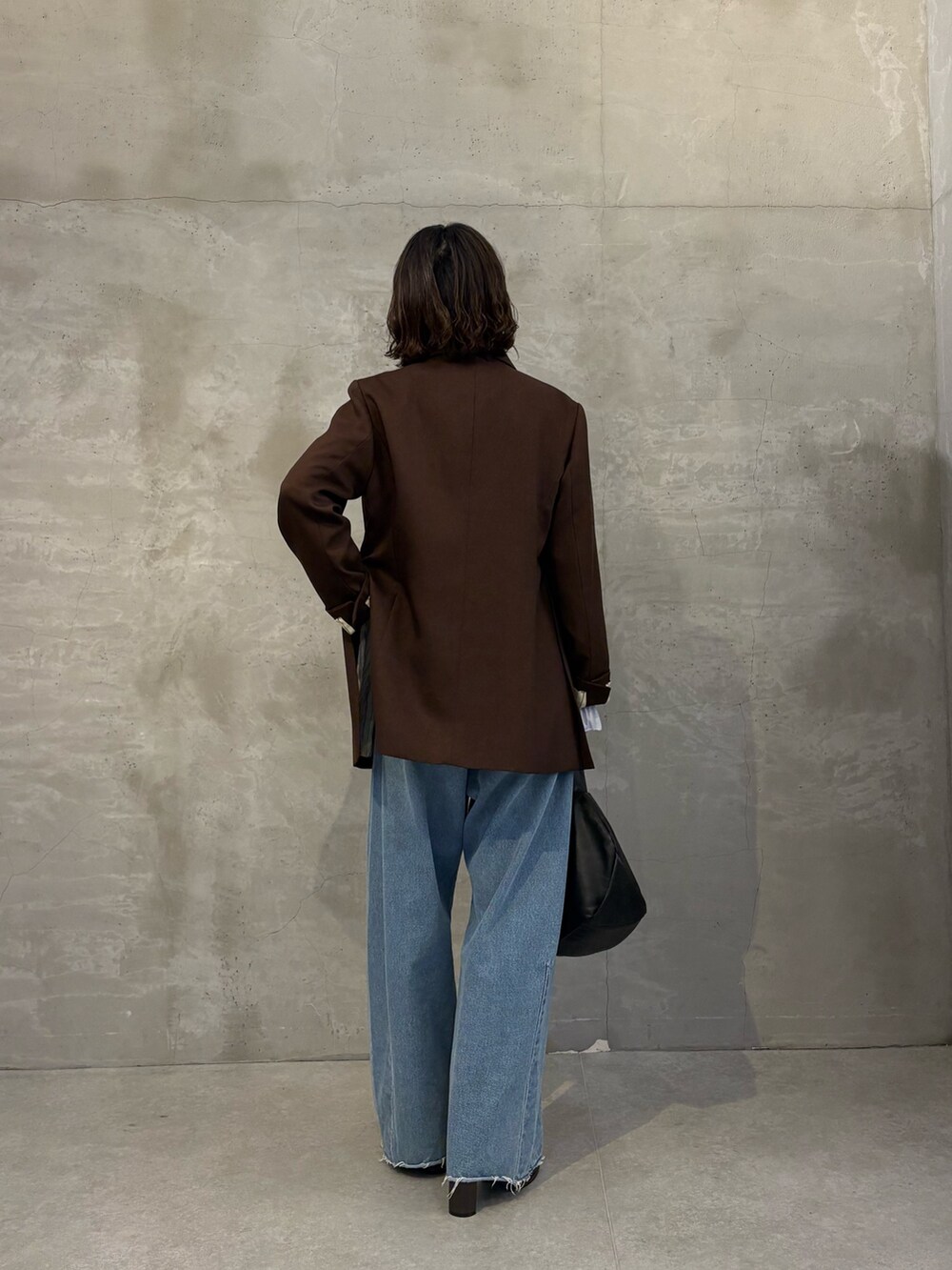 ブルー系のシャツ/ブラウス、ブルー系のデニムパンツ、ブラック系のショルダーバッグを着用したレディースの秋コーディネートの3枚目の写真