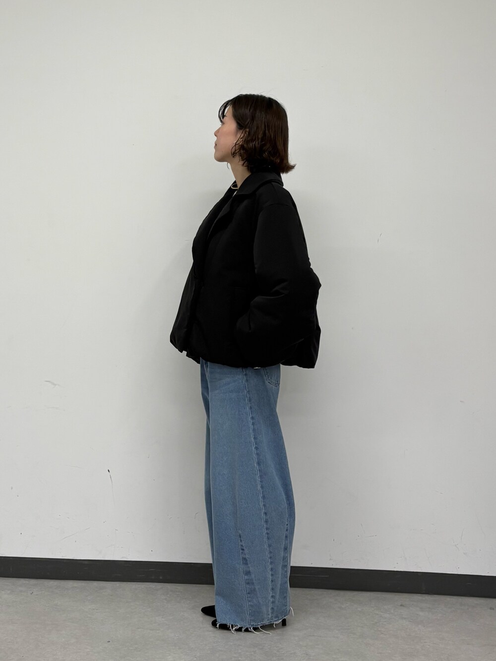 ブラック系のその他アウター、ブルー系のデニムパンツ、ホワイト系のニット/セーターを着用したレディースの秋コーディネートの4枚目の写真