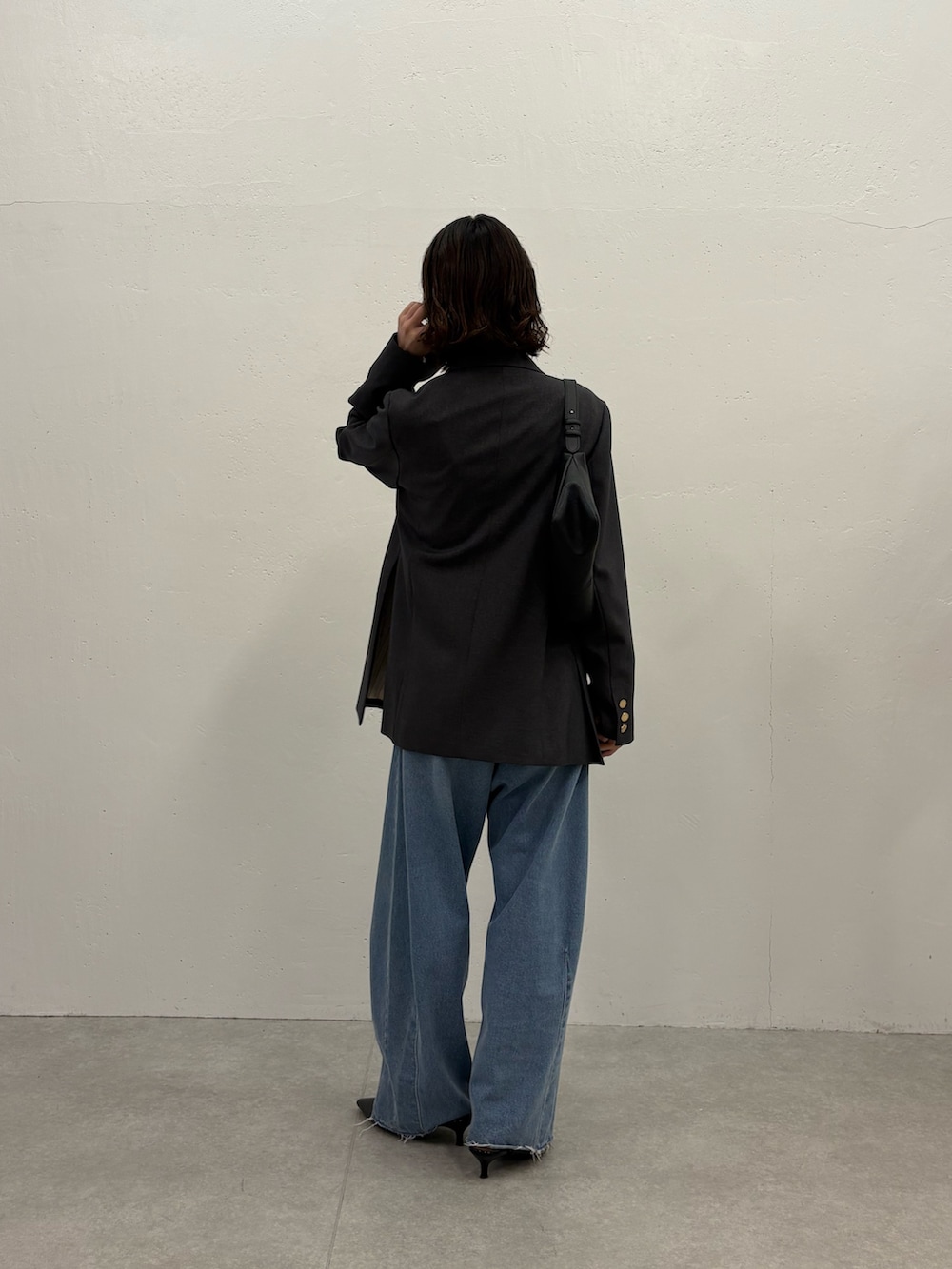 ホワイト系のTシャツ/カットソー、グレー系のテーラードジャケット、ブルー系のデニムパンツを着用したレディースの秋コーディネートの3枚目の写真