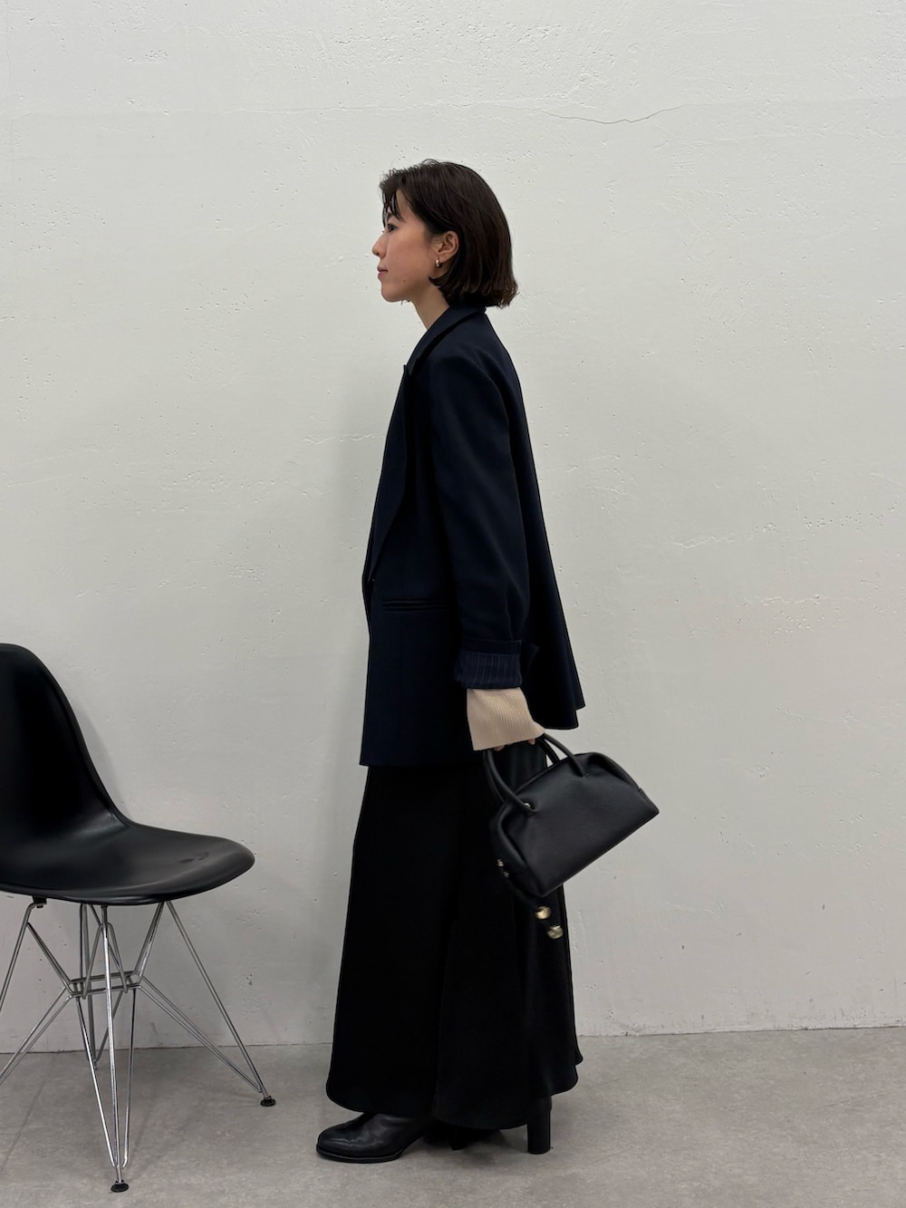 ブラック系のスカート、ブルー系のテーラードジャケット、ブラック系のボストンバッグを着用したレディースの冬コーディネートの2枚目の写真