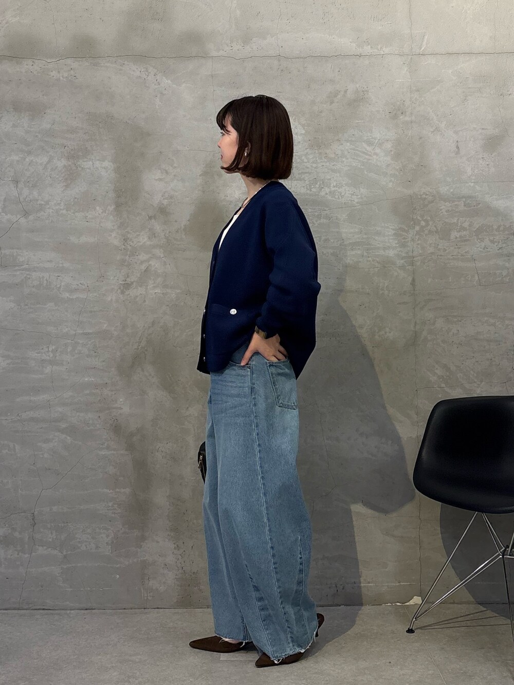 ブルー系のデニムパンツ、ブラック系のボストンバッグ、ブルー系のカーディガン/ボレロを着用したレディースの冬コーディネートの4枚目の写真