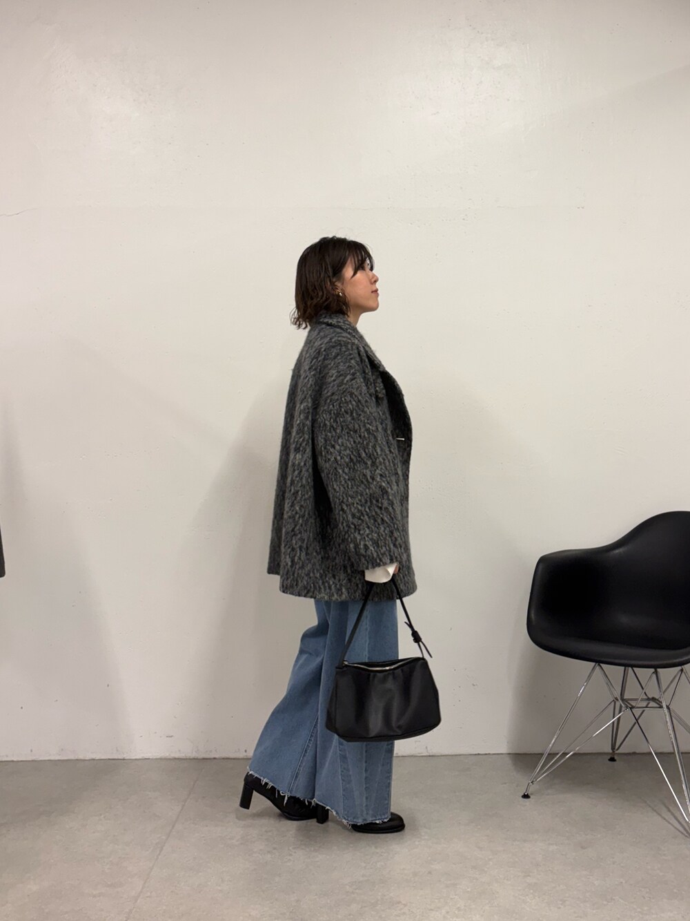 ホワイト系のニット/セーター、ブルー系のデニムパンツ、ブラック系のショルダーバッグを着用したレディースの秋コーディネートの2枚目の写真