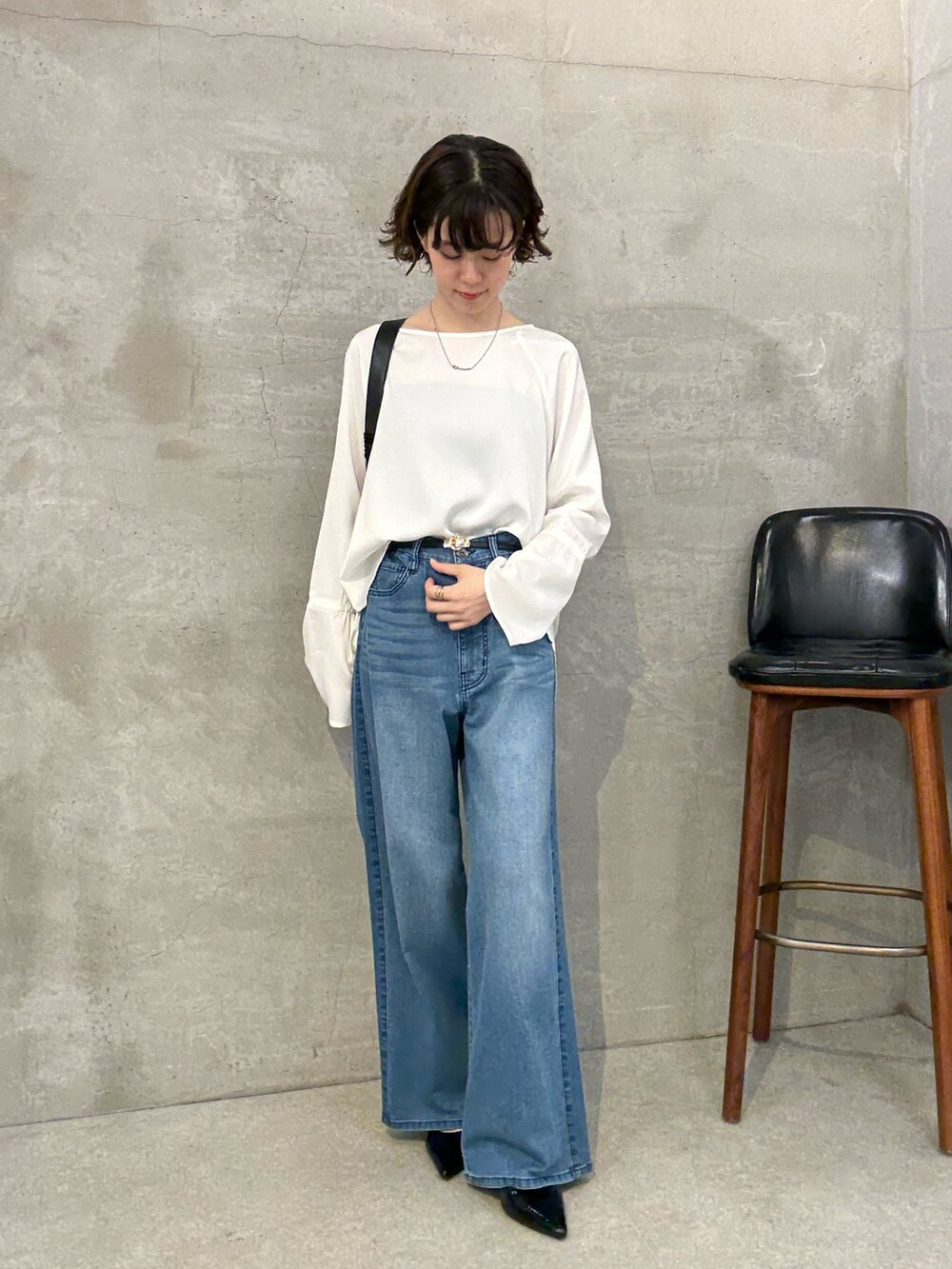 ブルー系のデニムパンツ、ホワイト系のシャツ/ブラウス、ブラック系のパンプスを着用したレディースの夏コーディネートの4枚目の写真