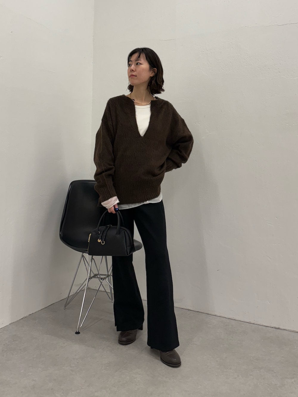 ブラック系のその他パンツ、ブラック系のボストンバッグ、ブラック系のブーツを着用したレディースの秋コーディネートの5枚目の写真