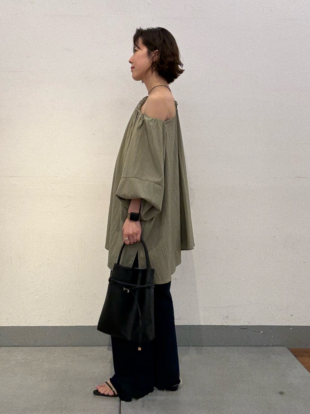 ブルー系のデニムパンツ、グリーン系のシャツ/ブラウス、シルバー系のネックレスを着用したレディースの夏コーディネートの3枚目の写真