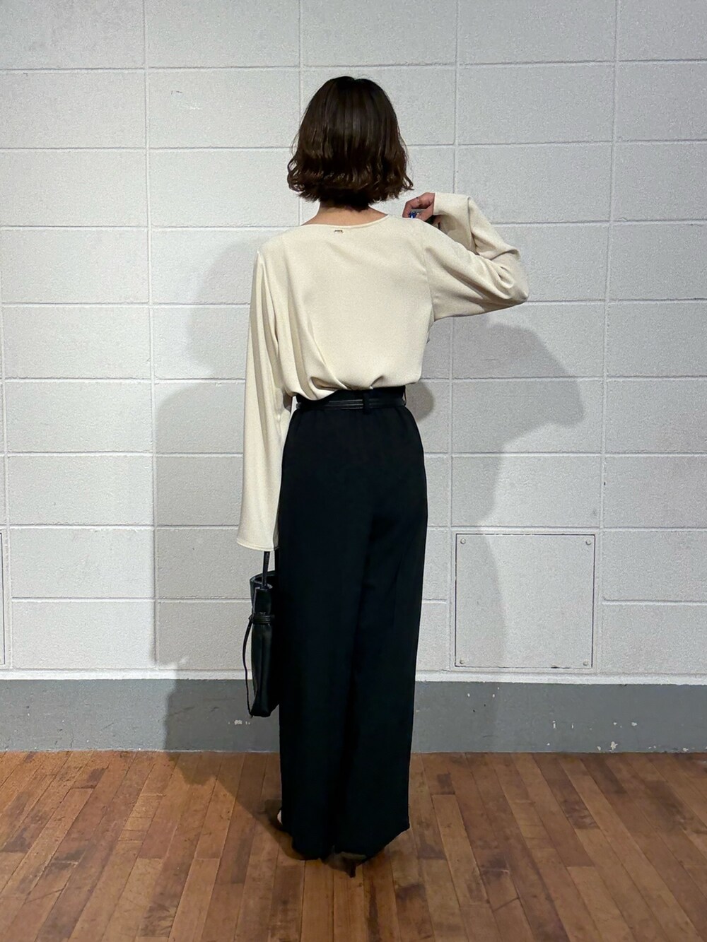 ブルー系のスラックス、ブラウン系のパンプス、ホワイト系のシャツ/ブラウスを着用したレディースの秋コーディネートの3枚目の写真