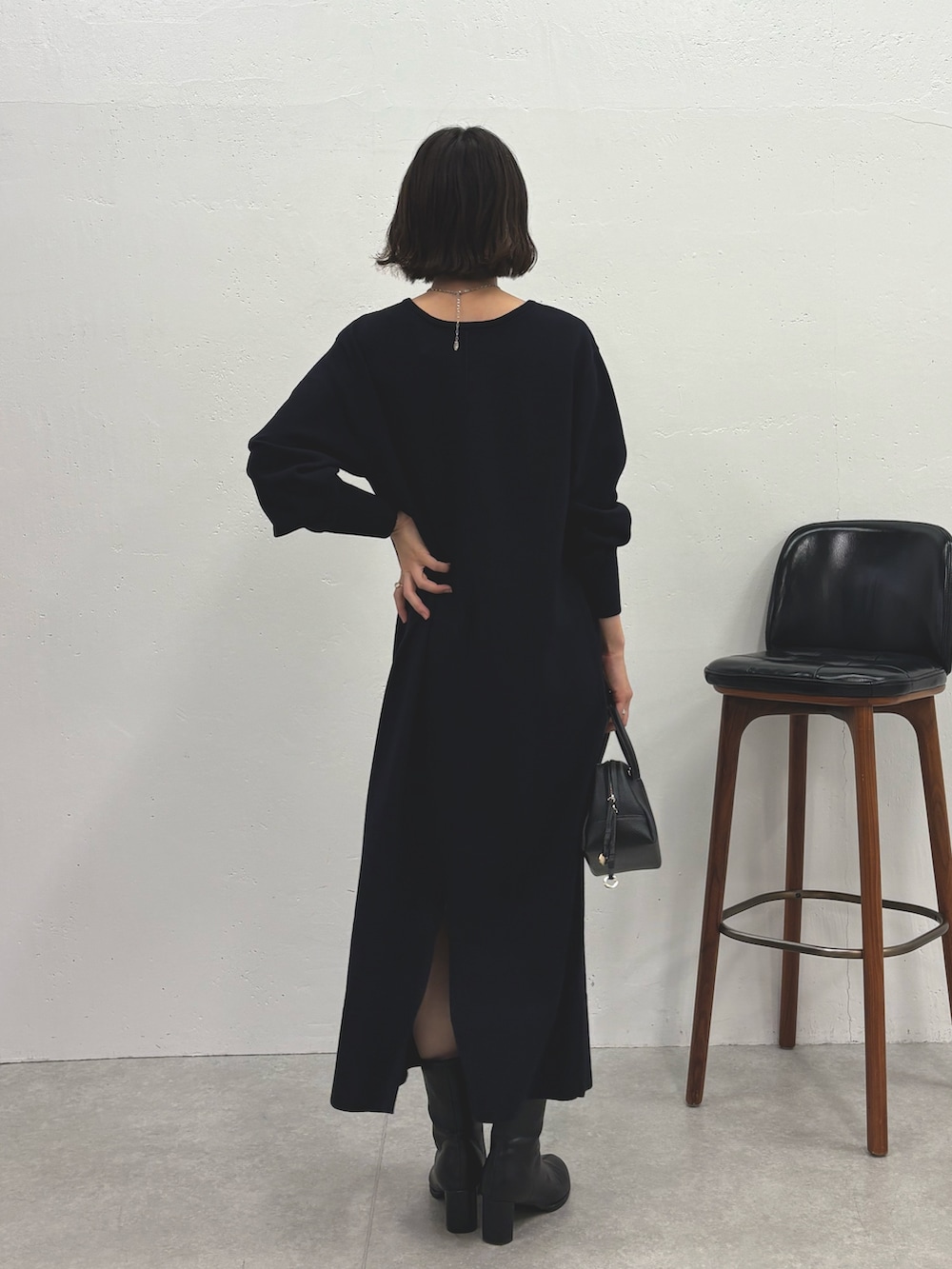 ブルー系のワンピース、ブラック系のブーツ、ブラック系のボストンバッグを着用したレディースの秋コーディネートの3枚目の写真