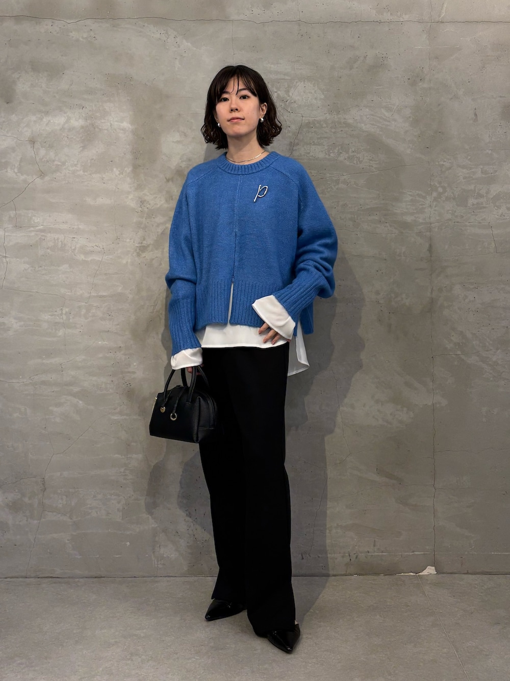 ブルー系のニット/セーター、ホワイト系のシャツ/ブラウス、ブラック系のその他パンツを着用したレディースの秋コーディネートの4枚目の写真