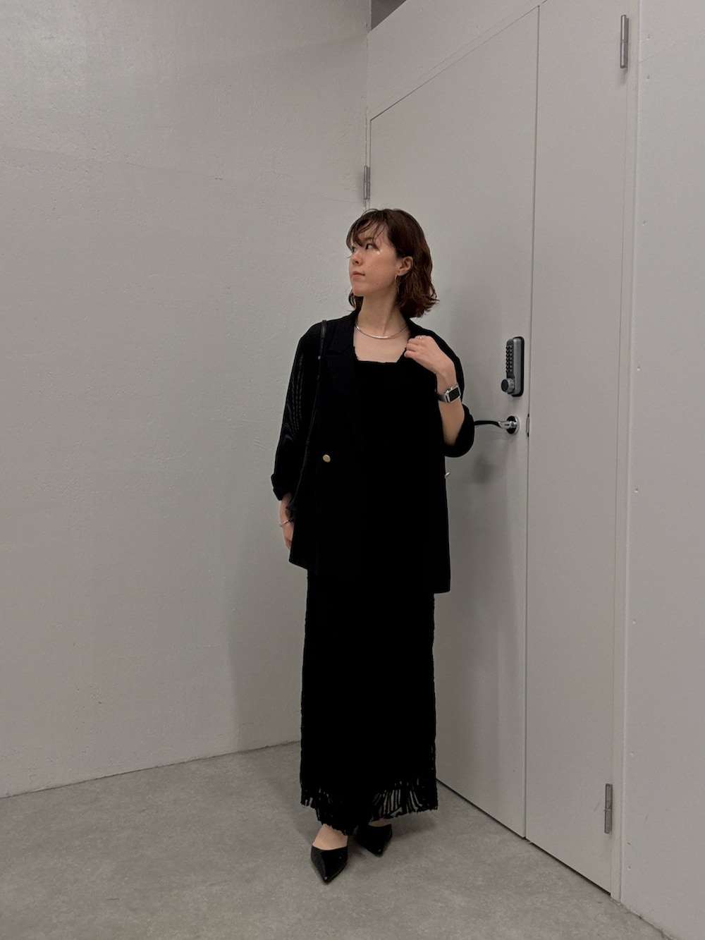 ブラック系のワンピース、ブラック系のテーラードジャケット、ブラック系のパンプスを着用したレディースの夏コーディネートの5枚目の写真