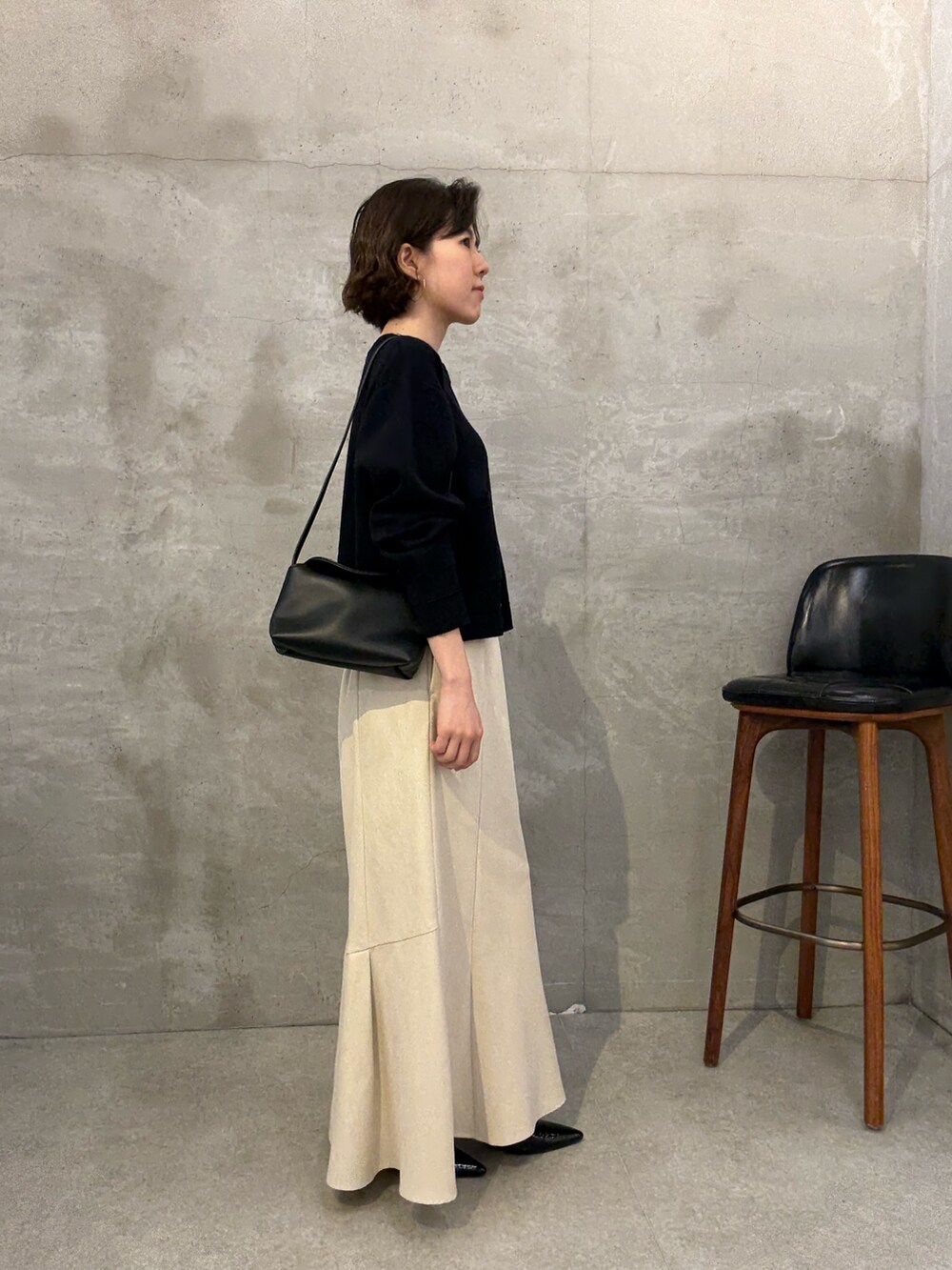 ホワイト系のスカート、ブルー系のカーディガン/ボレロ、ブラック系のショルダーバッグを着用したレディースの夏コーディネートの3枚目の写真