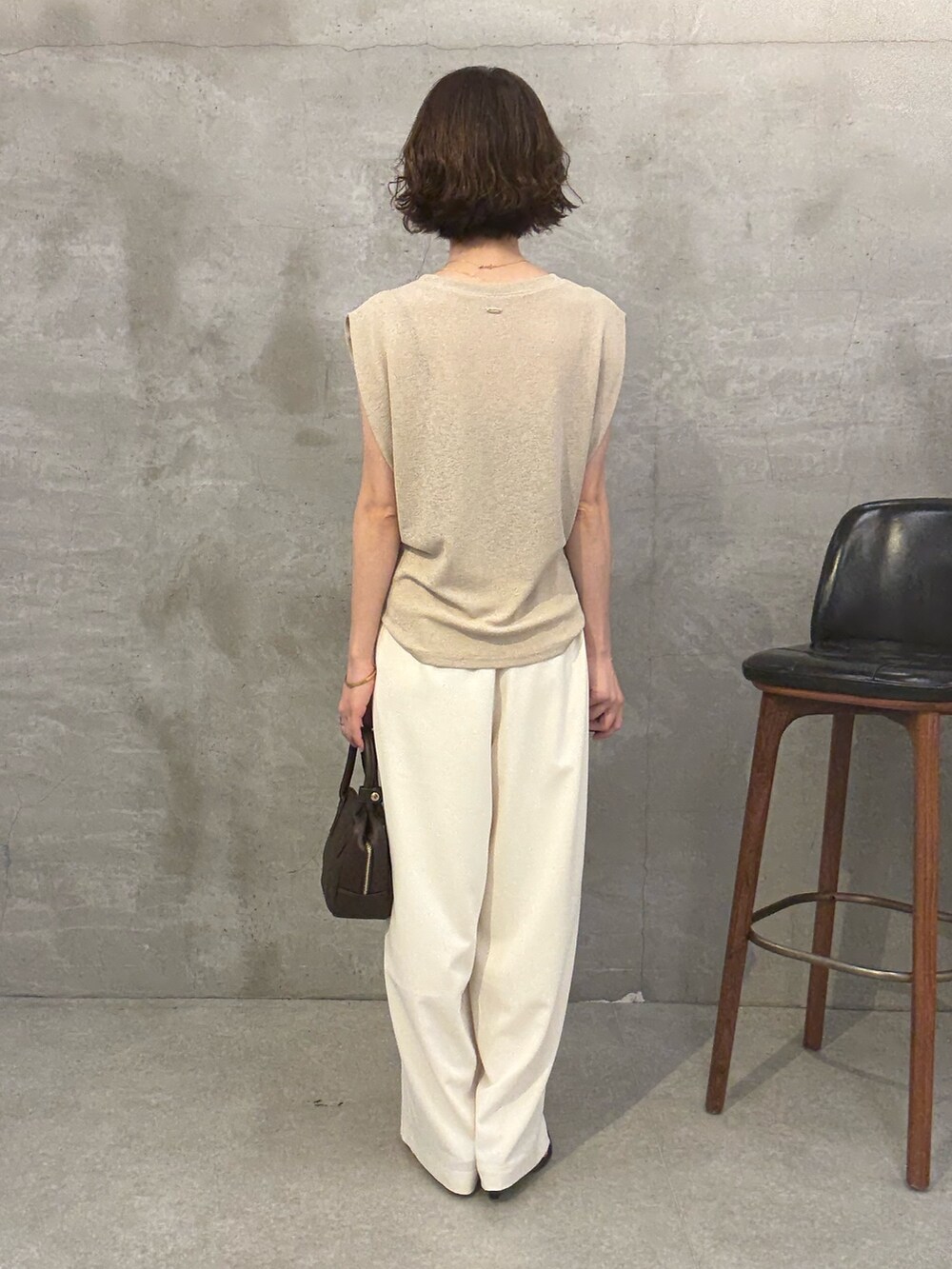 ホワイト系のその他パンツ、ベージュ系のニット/セーター、ブラウン系のショルダーバッグを着用したレディースの夏コーディネートの3枚目の写真