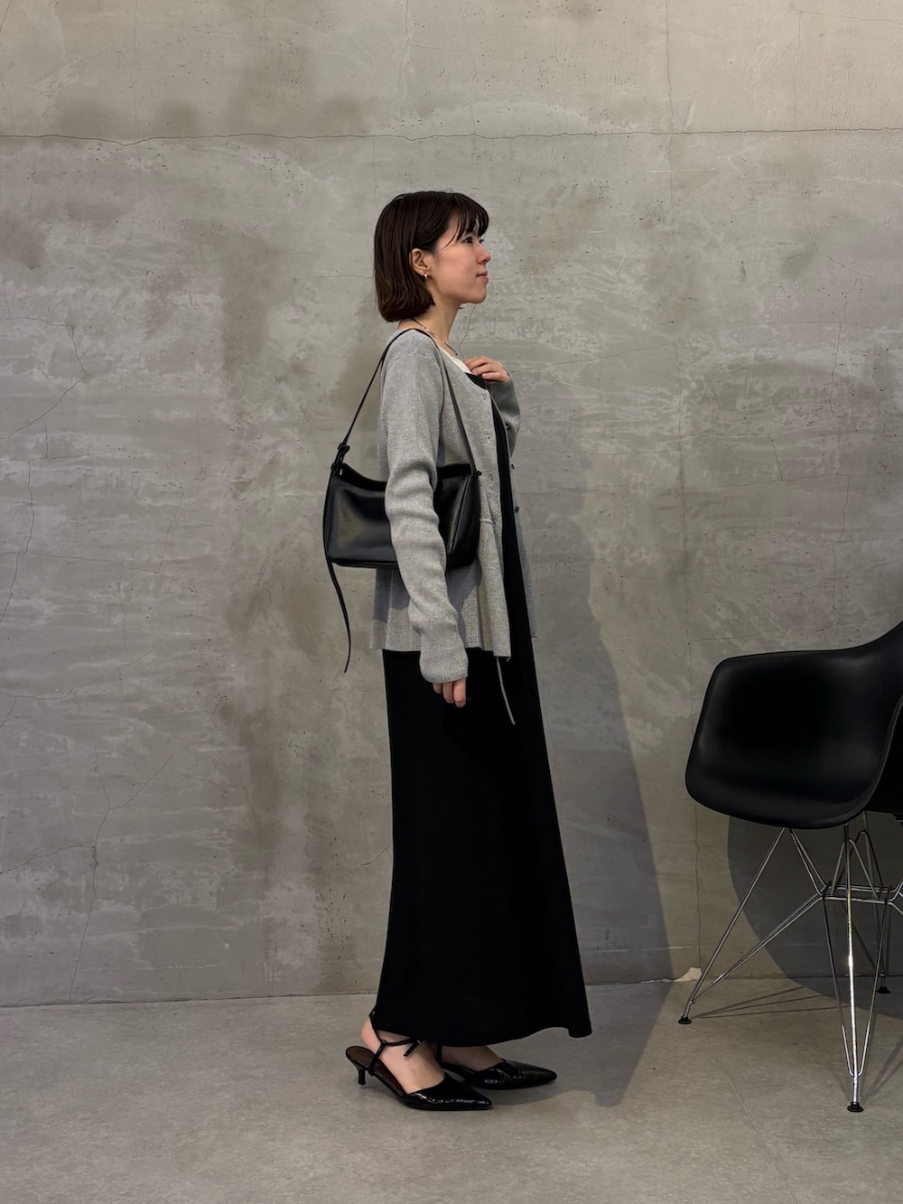 ブラック系のワンピース、ブラック系のショルダーバッグ、グレー系のカーディガン/ボレロを着用したレディースの冬コーディネートの5枚目の写真