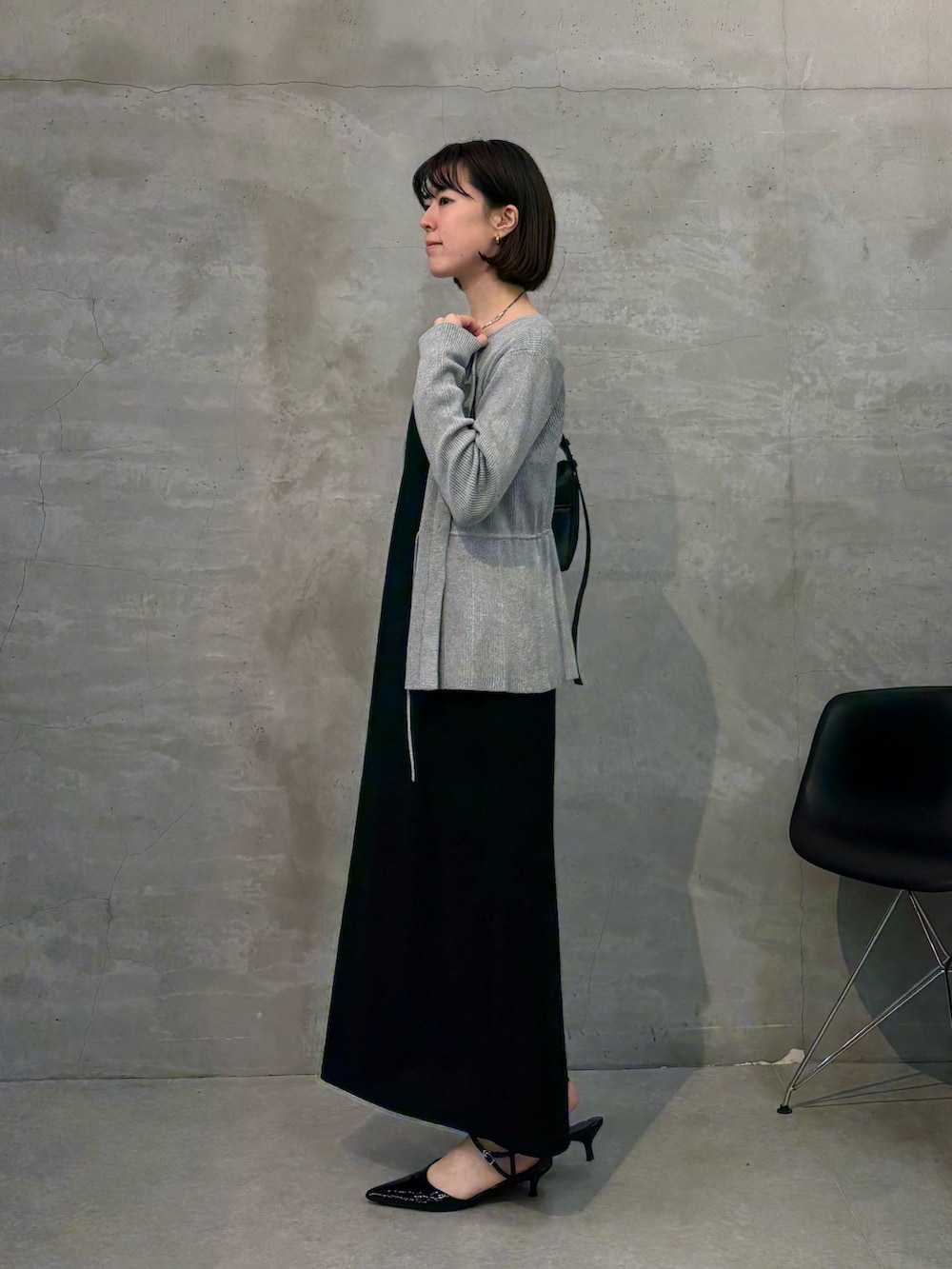 ブラック系のワンピース、ブラック系のショルダーバッグ、グレー系のカーディガン/ボレロを着用したレディースの冬コーディネートの2枚目の写真