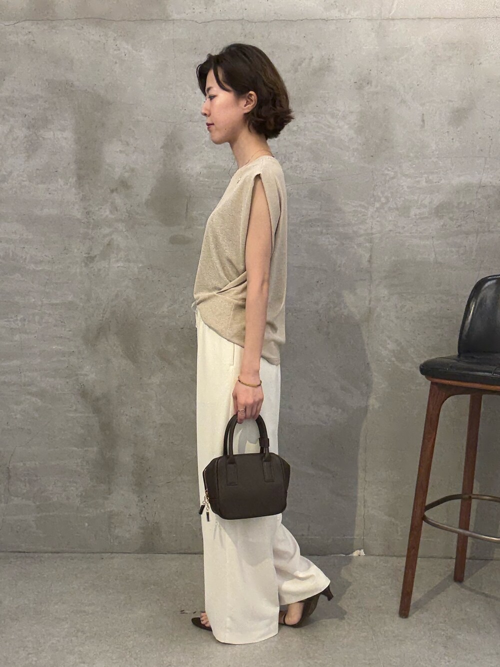ホワイト系のその他パンツ、ベージュ系のニット/セーター、ブラウン系のショルダーバッグを着用したレディースの夏コーディネートの2枚目の写真